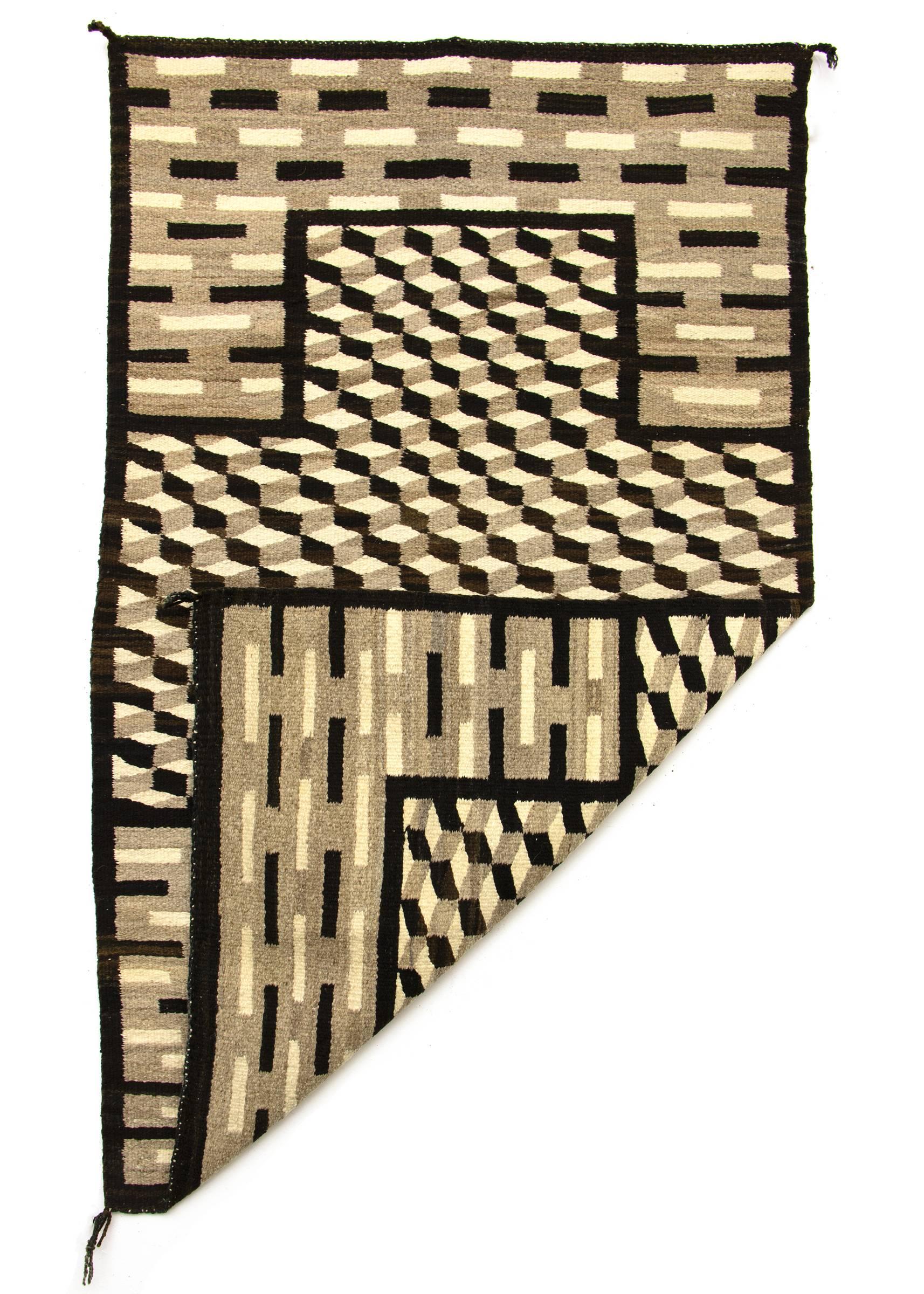 Known as an optical or tumbling block design, this textile has a central cross motif and is woven of native hand spun wool in natural ivory, grey and brown fleece.

This weaving is well suited for use as a wall hanging, area rug or furniture throw.