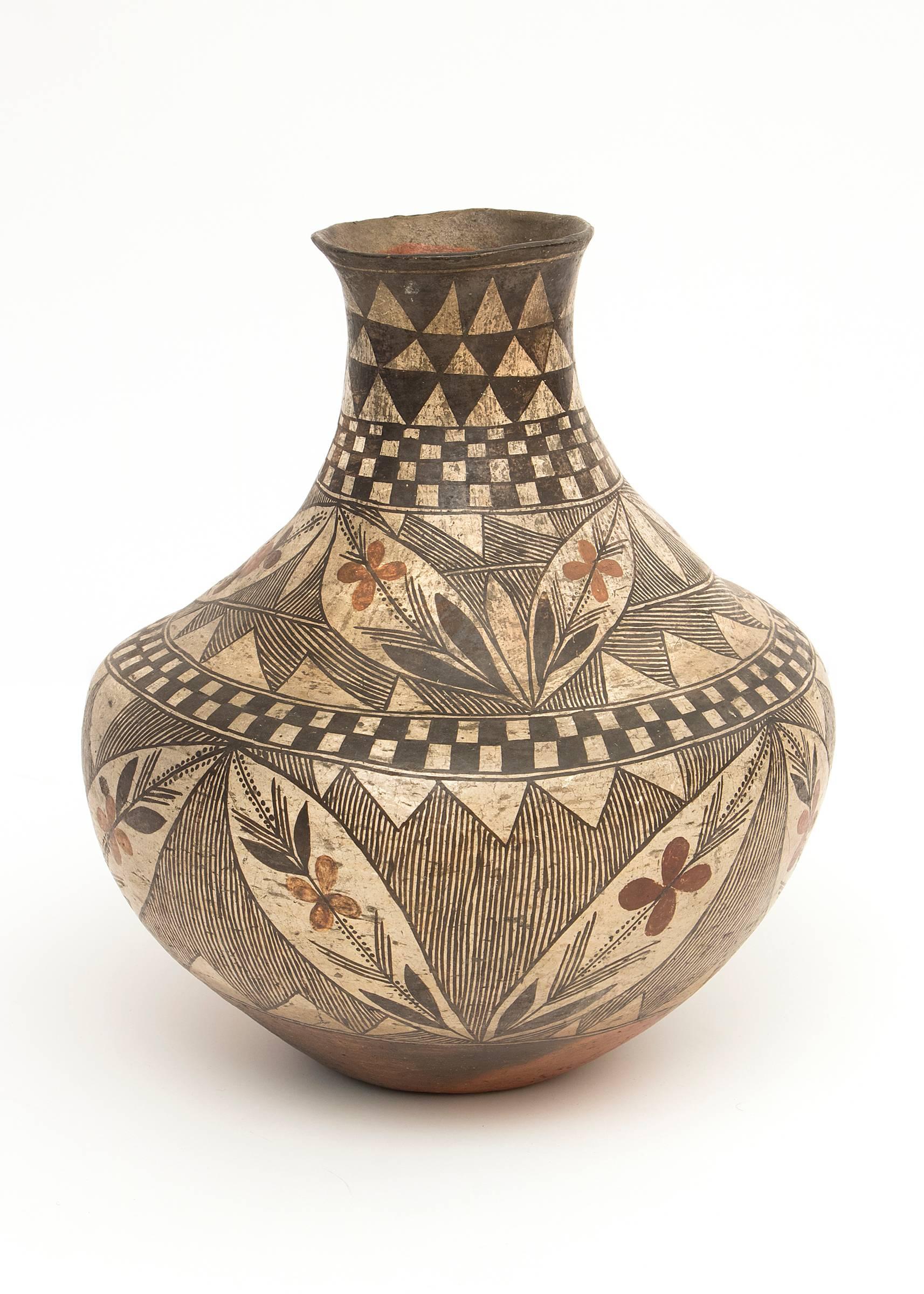 A rare antique Isleta Pueblo four-color earthenware jar constructed by hand and finely painted in slip glazes with Classic Acoma elements including floriate motifs and checkerboard elements.

Acoma Pueblo is located in New Mexico approximately 60