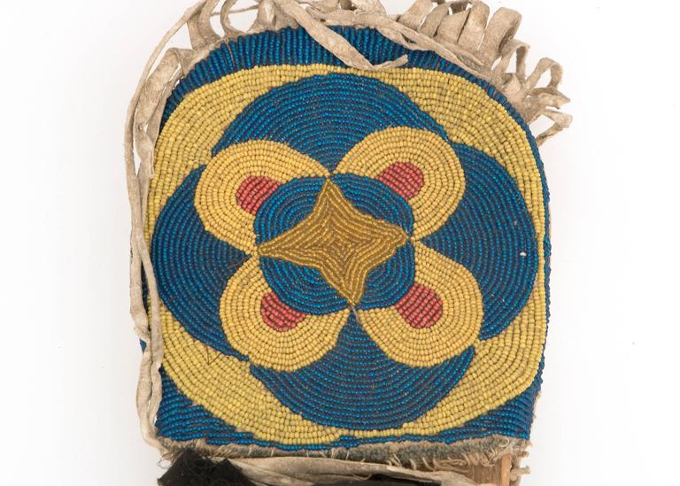 A doll cradle created as a toy for use by a Western Plateau girl. Constructed of native tanned hide stretched over a wooden backboard. Fully beaded in blue, yellow, red and white trade beads in Classic geometric and foliate designs. Fringed at the