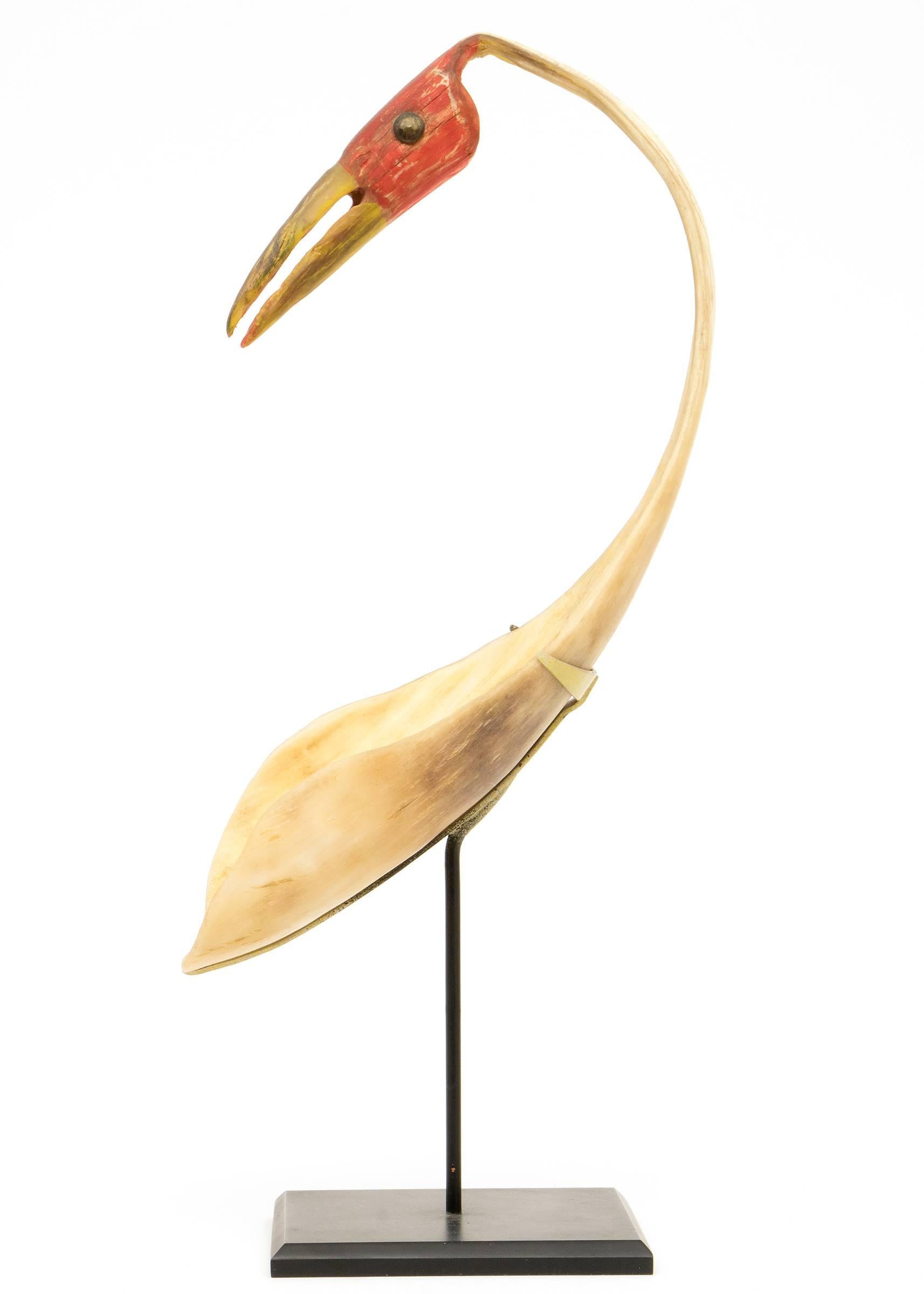 A horn spoon with a graceful bird form with red pigment. Custom display stand is included. Spoon measures 9 ¼ x 3 x 5 ½ inches, overall height when displayed on the stand is 12 ¼ inches.
