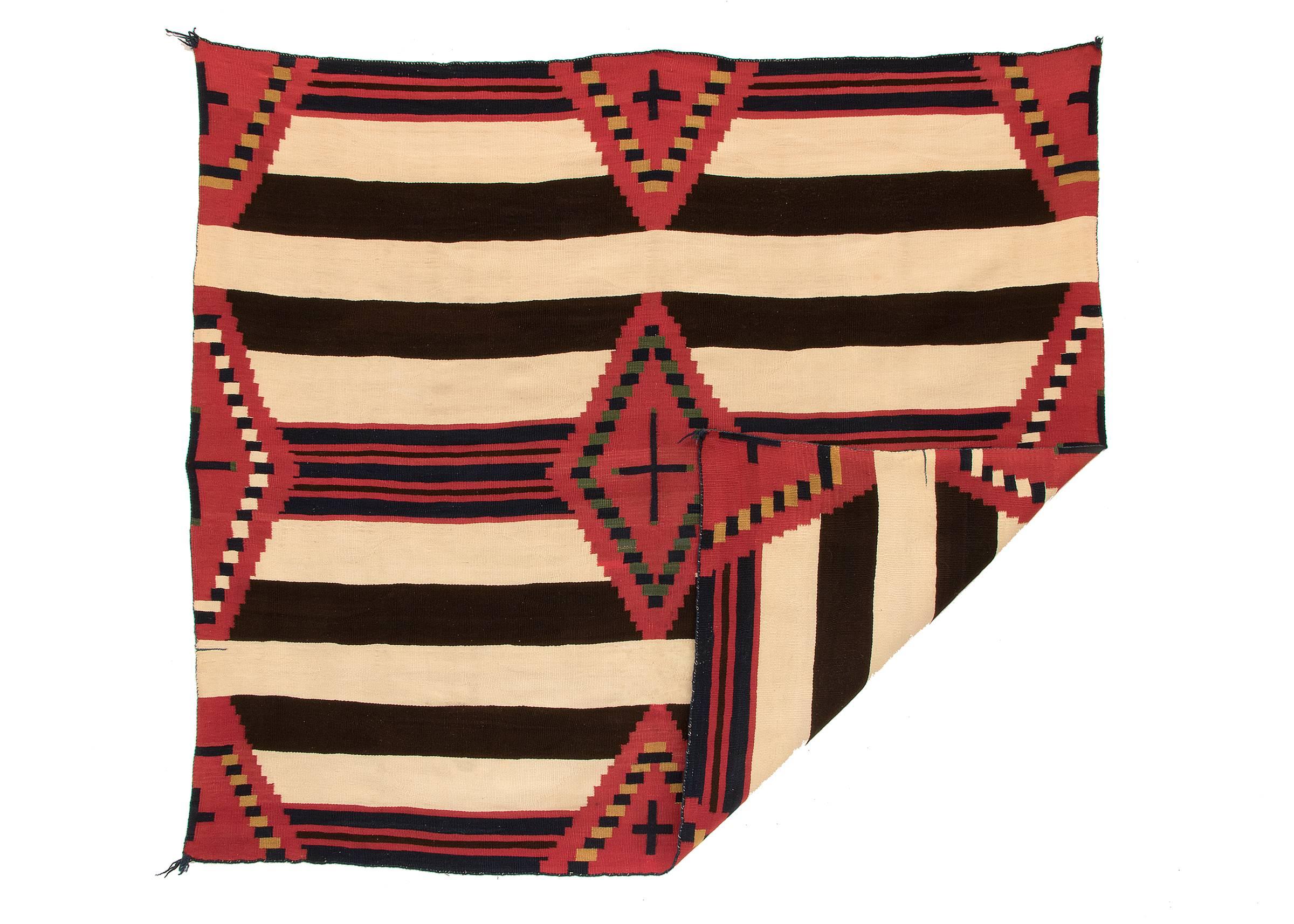 A third phase chiefs blanket in a nine-point pattern with cross motifs. Very finely woven of native handspun wool in natural fleece colors of ivory and brown with natural indigo blue and cochineal red. The yellow is likely a rabbitbrush dye and the