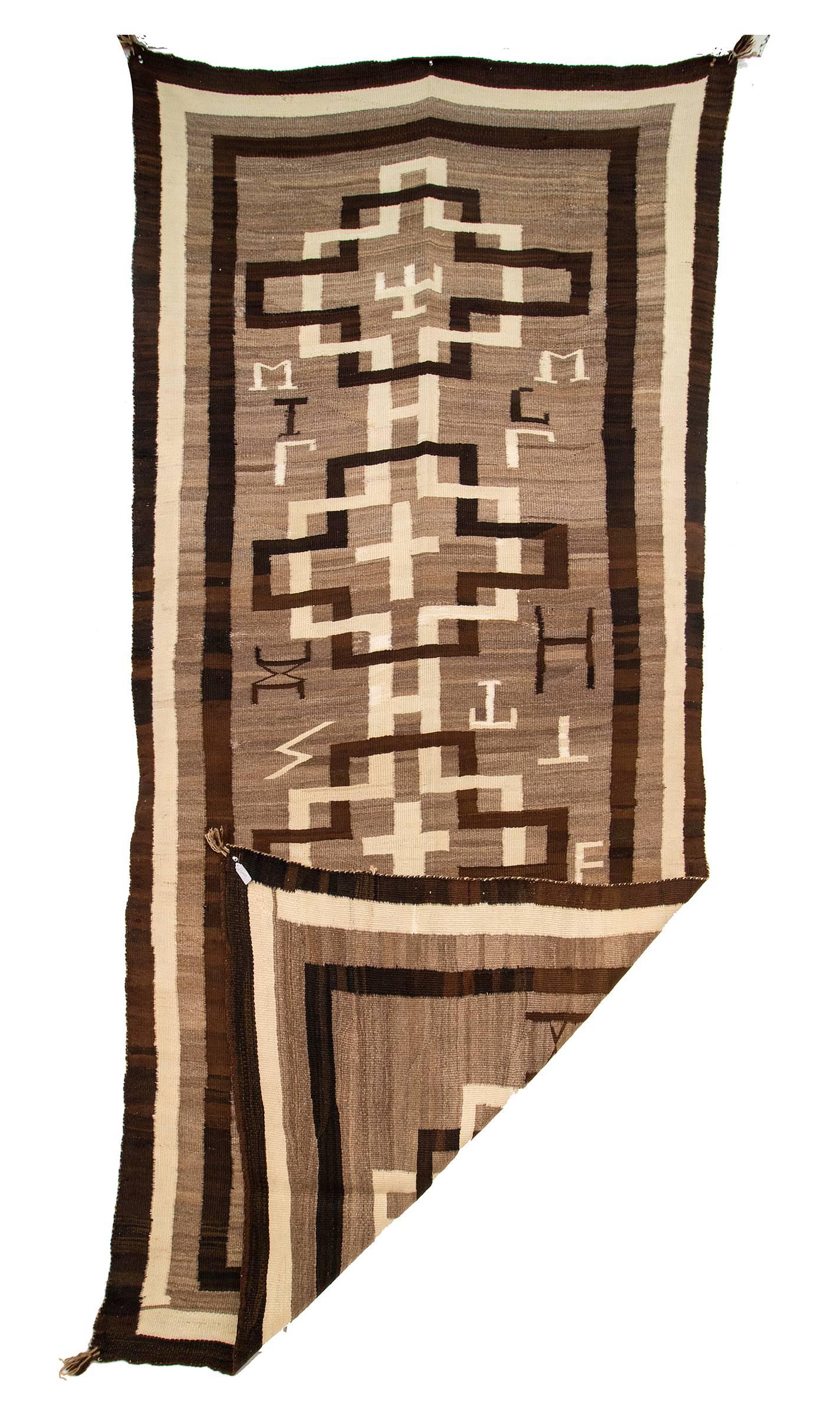 An elongated runner textile woven of native hand-spun in natural fleece colors of ivory, brown and brown/black. 

Well suited for use as an area rug, wall hanging or furniture covering/throw.
