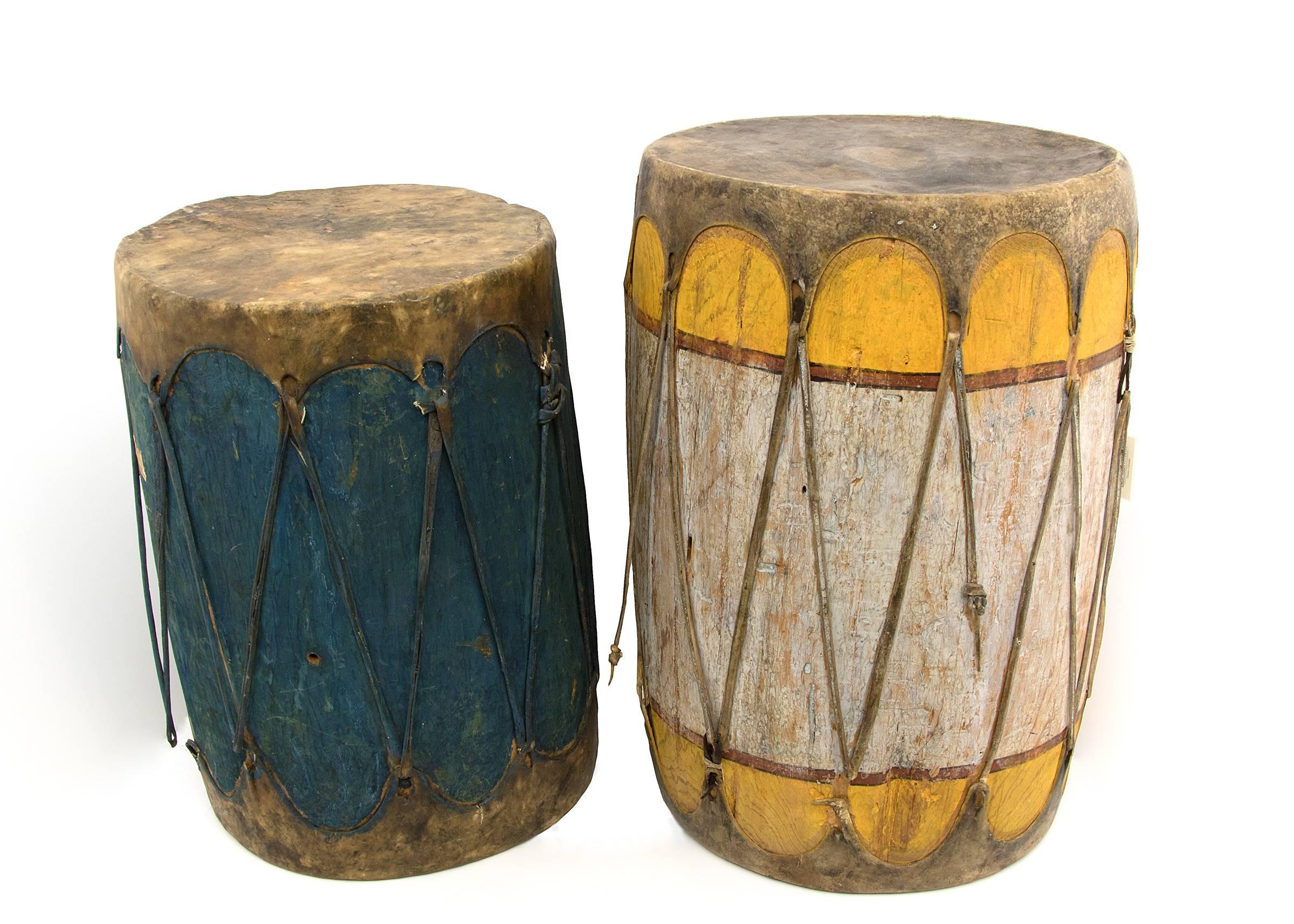 Two Pueblo drums from the early 20th century constructed of wood with stretched rawhide and vegetal paint.
Dimensions as displayed: 28 x 38 inches. Individual measurements: Left (blue): 24 H x 18 Di inches. Right (yellow): 28 H x 17 Di inches.
These