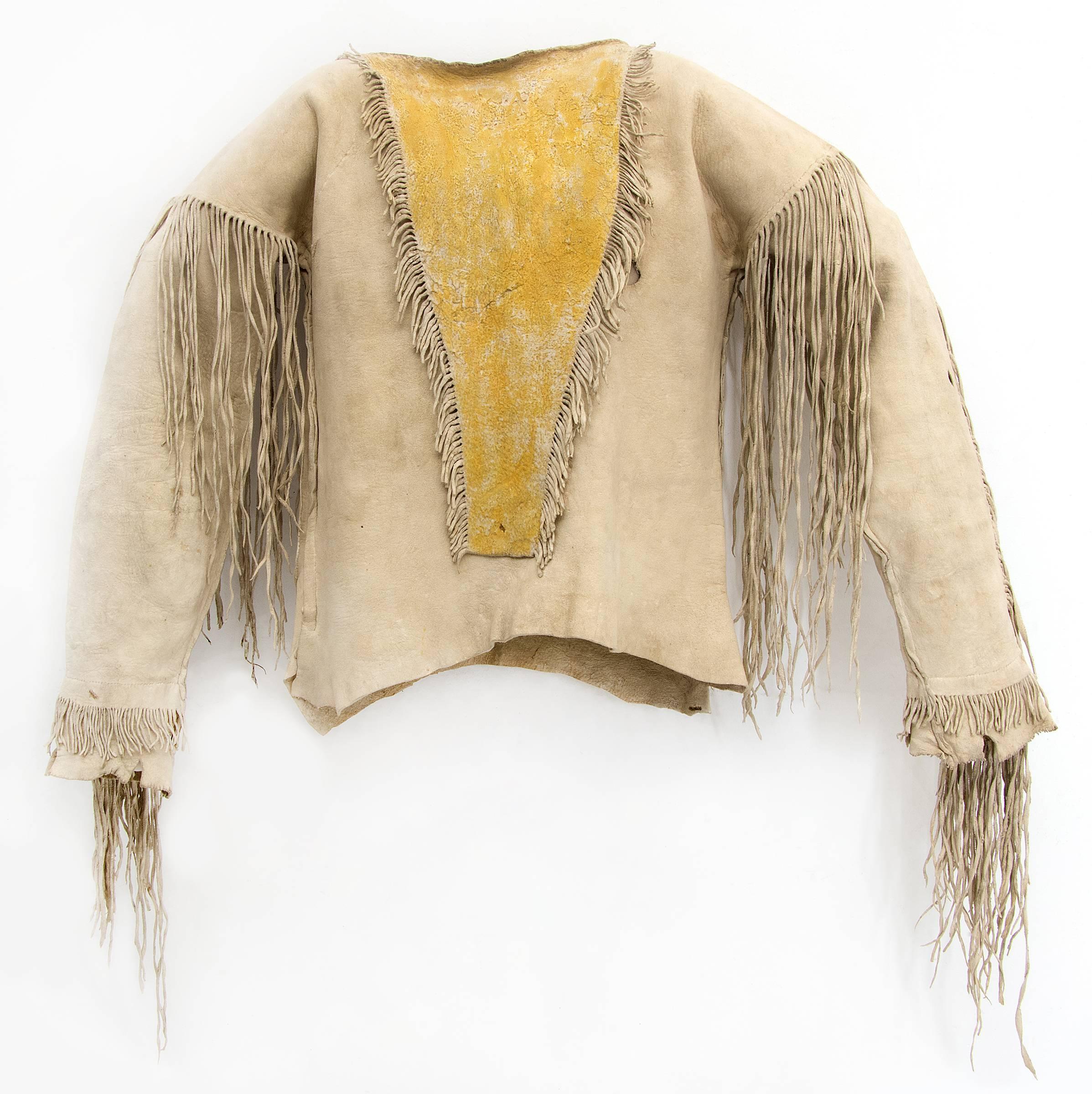 A shirt and leggings created for a boy (youth) composed of native tanned hide with fringe and yellow ochre pigment.

Overall dimensions of all pieces as displayed measure 60 x 46 x 2 inches
Shirt measures: 24 x 59 inches (with arms