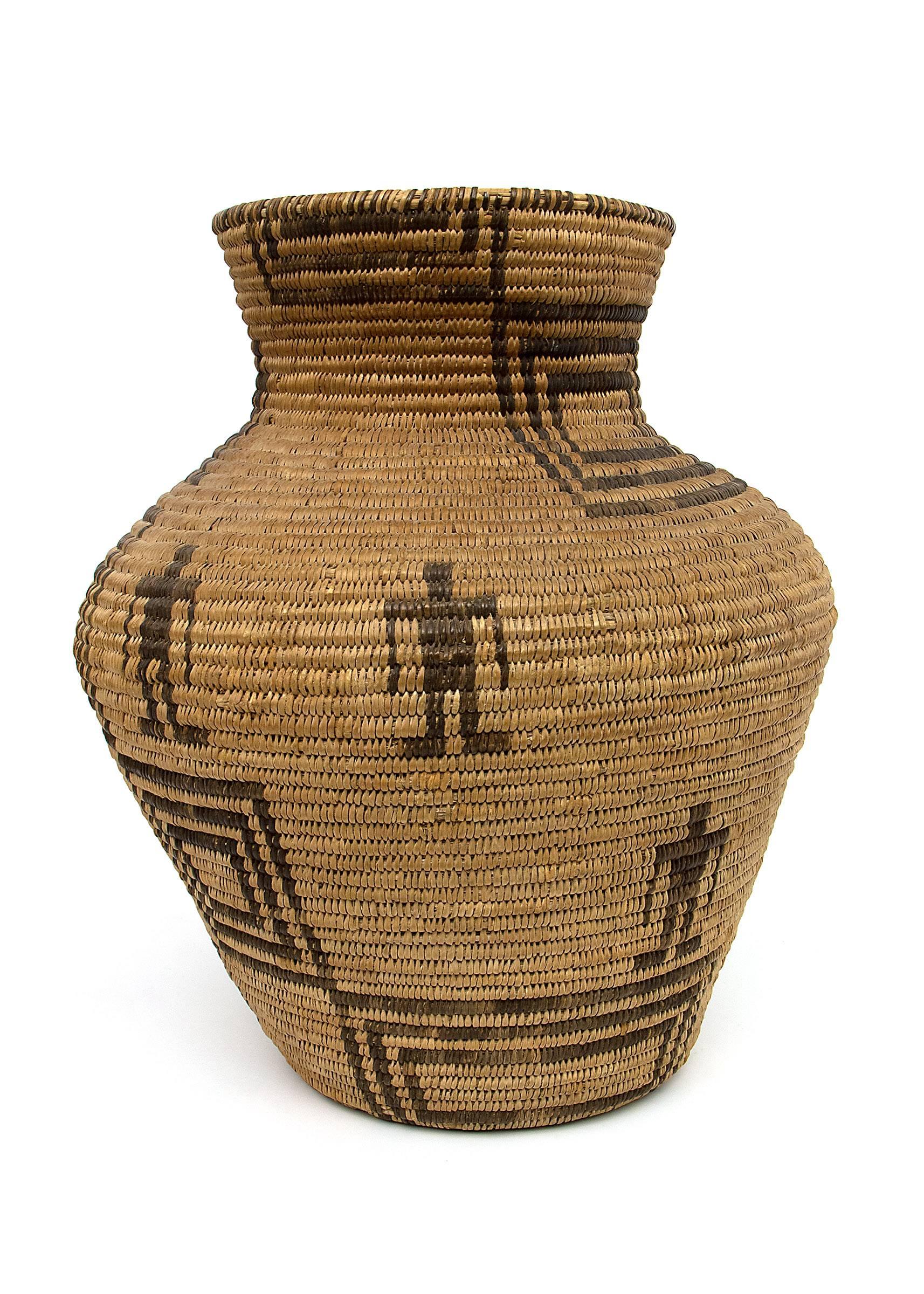 This antique North American Indian Olla is woven of willow and devil's claw with geometric and humanoid elements. The Apache, a nomadic American Indian tribe, followed the buffalo and ranged across the American Southwest including areas of Arizona,