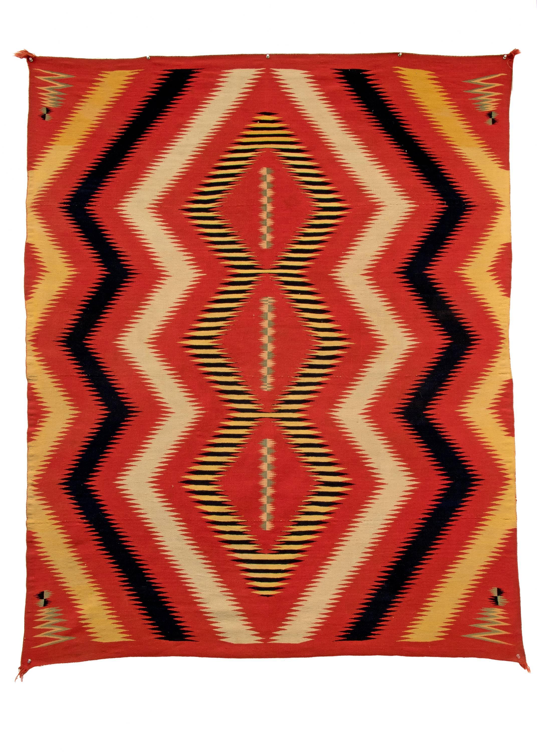 Navajo Blanket woven in a Serape style wearing blanket, circa 1875, expertly woven of native hand-spun wool in a pattern similar to Navajo Germantown eye dazzlers. The red yarns are handspun with aniline dye, the blue yarns are handspun with indigo