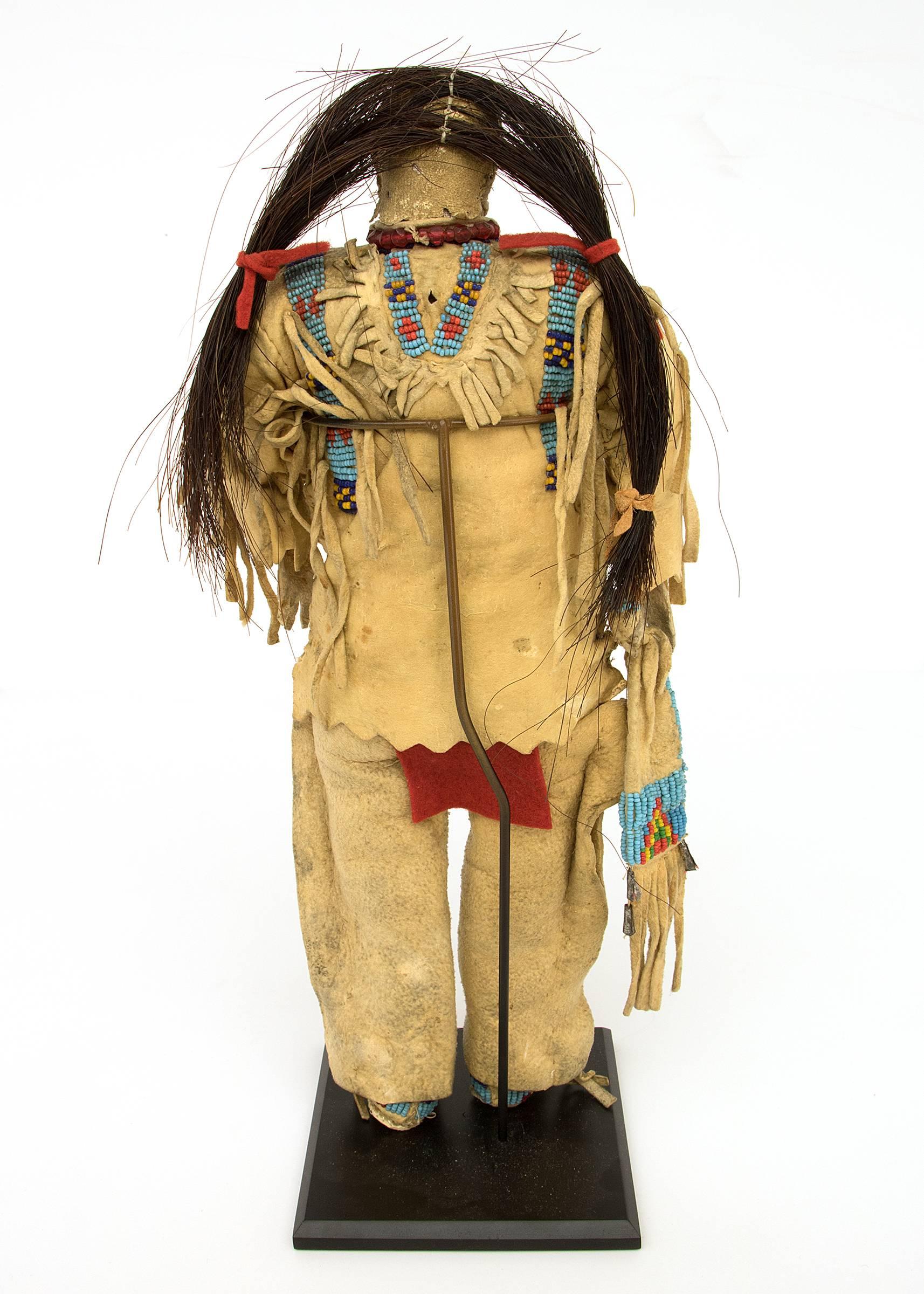 Dolls such as this were created as playthings for young girls. Formed out of native tanned hide and likely stuffed with grass, the doll is a replica of a Sioux warrior and the clothing and accessories denote that this was made by and for a member of
