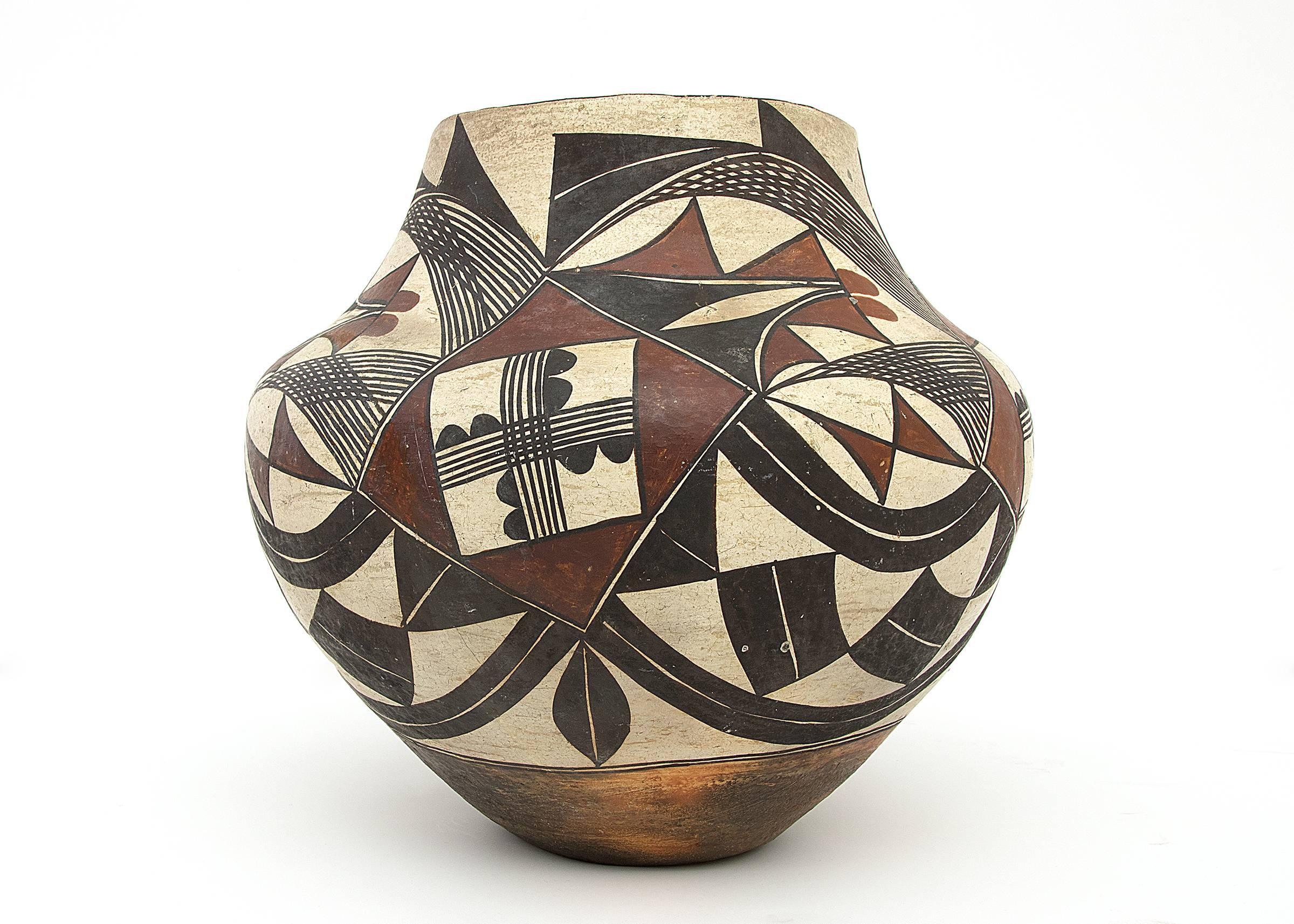 Built by hand from native clay by an American Indian potter at Acoma Pueblo and expertly hand-painted with slip glazes in a sophisticated composition comprised of stylized botanical and geometric elements. Acoma Pueblo is located in New Mexico