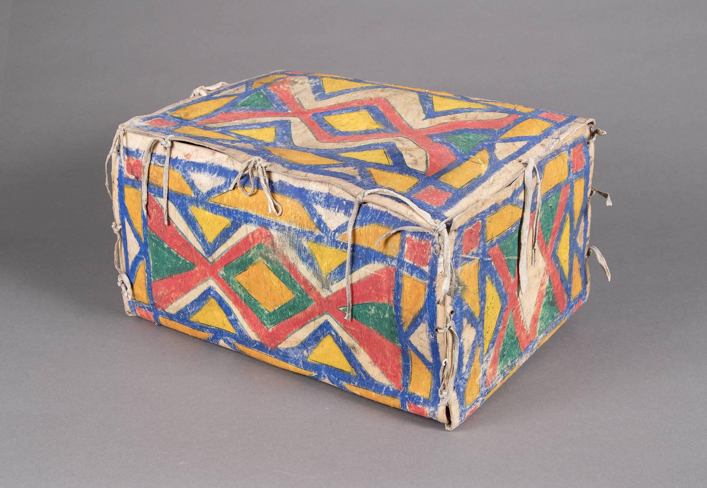 An antique Sioux (Plains Indian) parfleche container in a box form. Constructed of rawhide and painted with natural pigments (vegetal paints) in abstract geometric designs. A Nomadic tribe, the Sioux are associated with areas of the great plains of