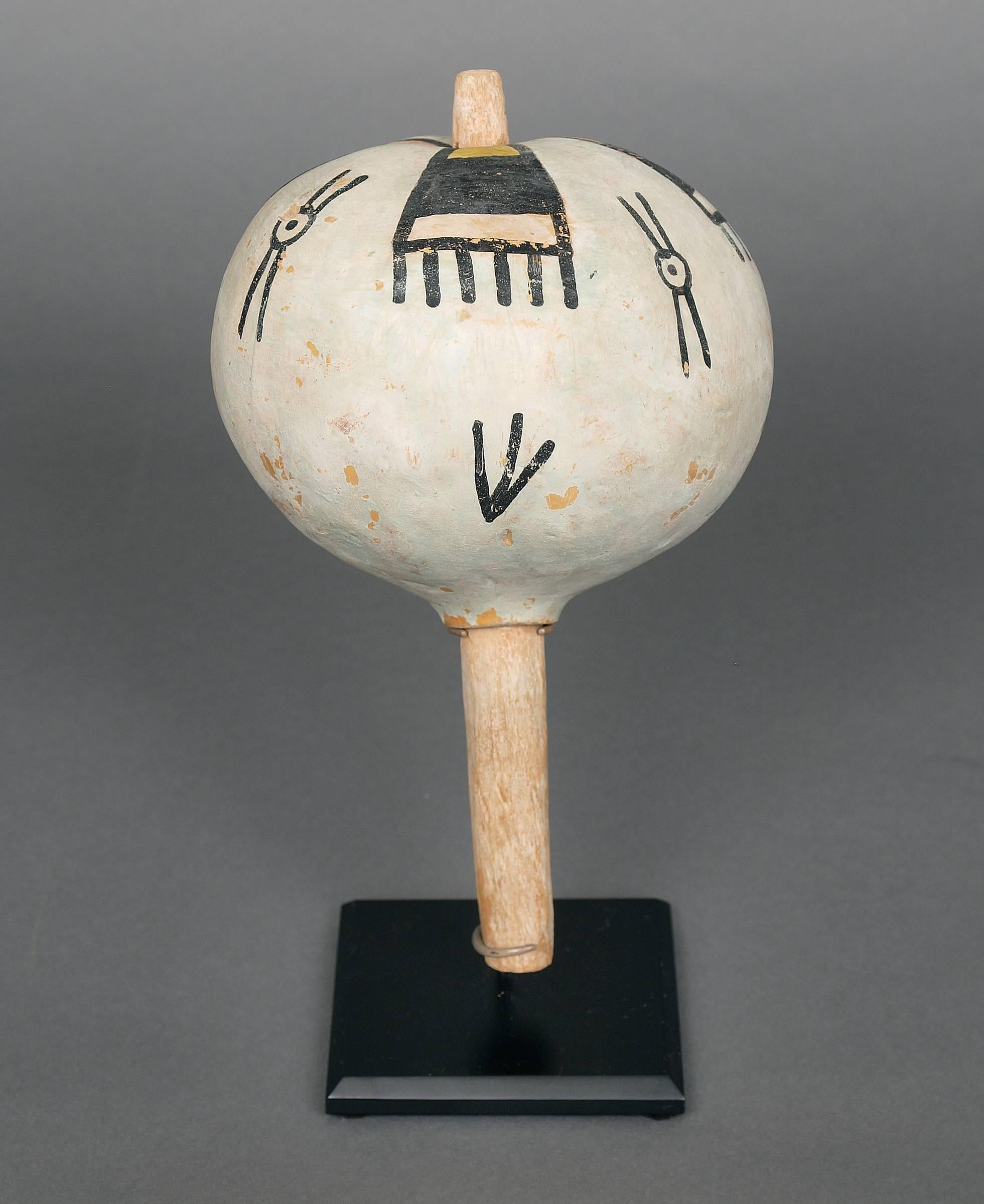 Gourd rattle with black, white, yellow ochre paint and a wooden handle. Created by a Hopi Artist around 1900.

Custom display stand is included.

Expedited and International Shipping is available, please contact us for an estimate.