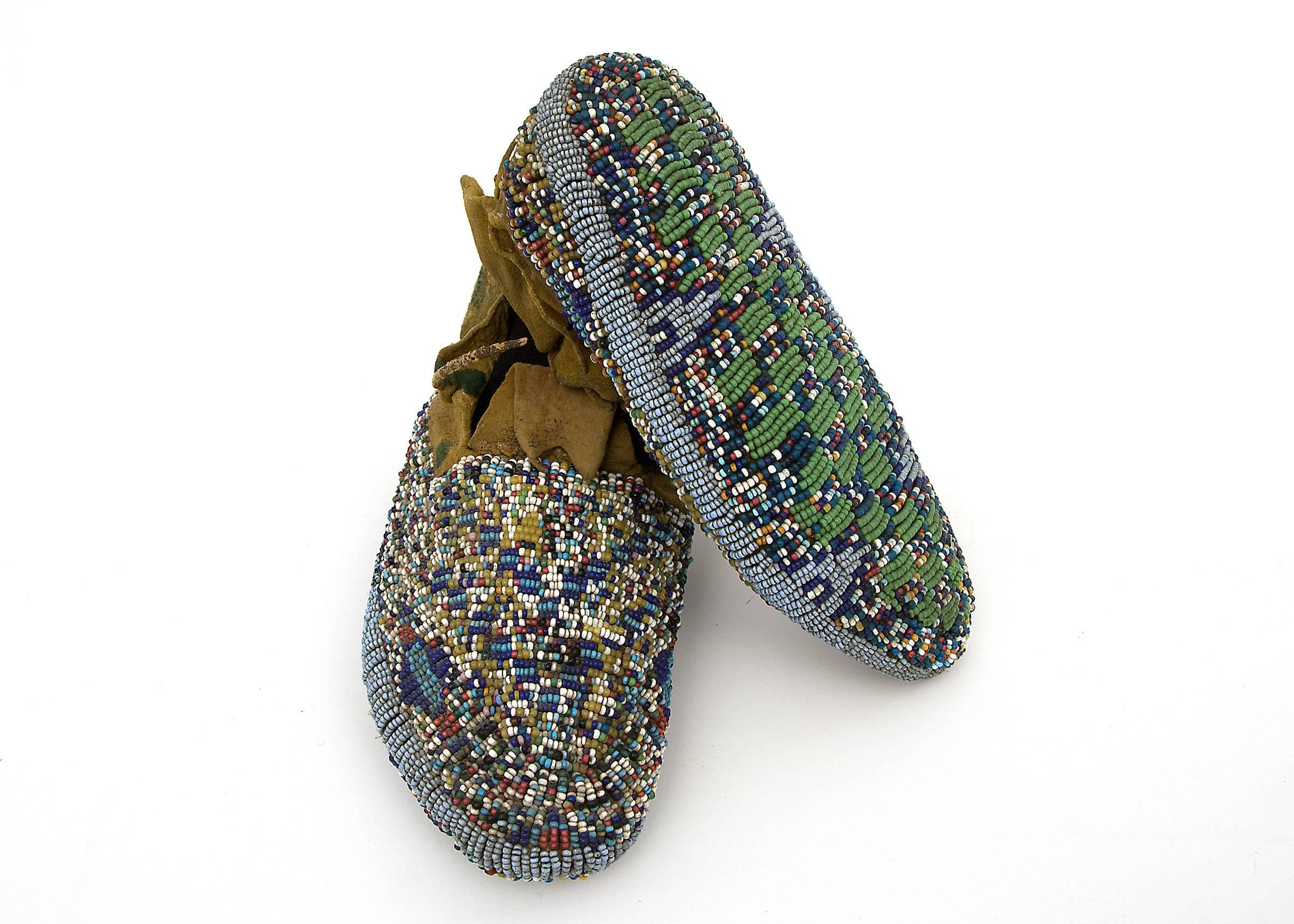 Meticulously created for a child, these ceremonial moccasins, were constructed from native tanned hide and elaborately decorated with multicolored glass trade beads. The soles are fully beaded, indicating that these were made for the child to wear