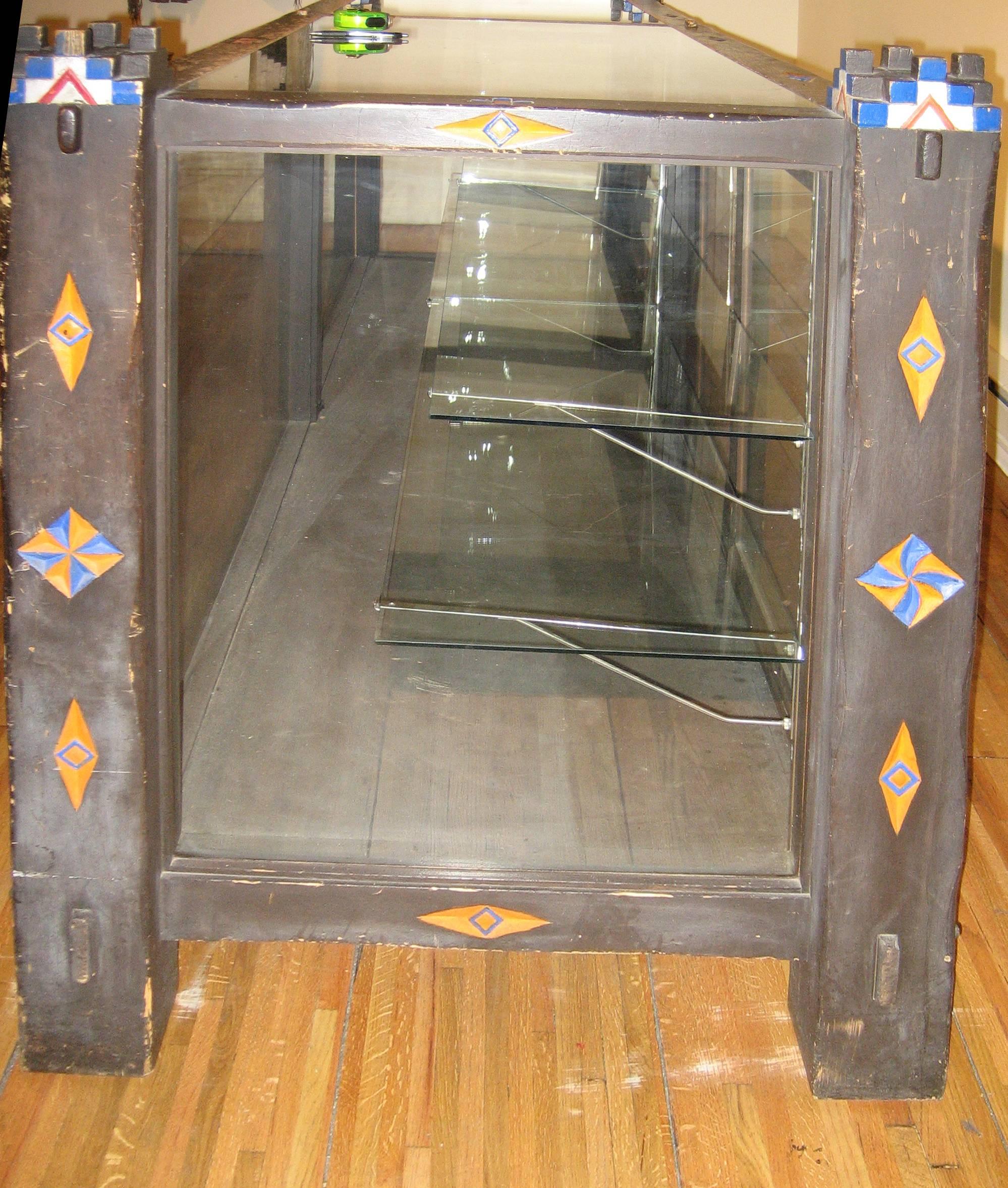 A charming hand-carved display case with Native American and New Mexican iconography including the Zuni sun symbol. Likely dating to the 1940s, this is believed to have been a display case in a New Mexican hotel, possibly the La Fonda in Santa Fe or