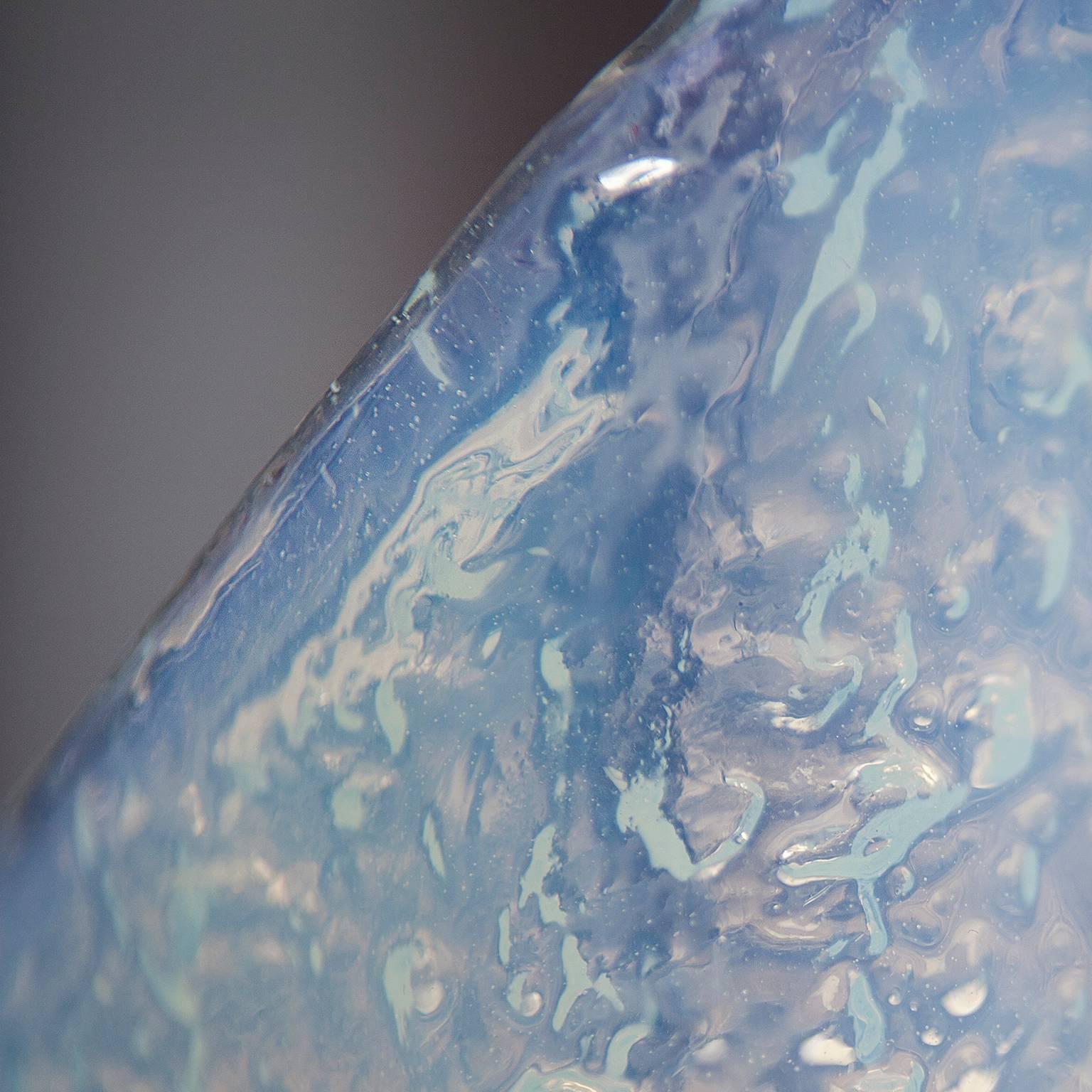 Das Opalglas dieser Mazzega-Wandleuchter spendet ein wunderbar warmes Licht. Hinter dem blau-weißen Muranoglas verbergen sich zwei Steckdosen. Es sind 7 Wandleuchter verfügbar.