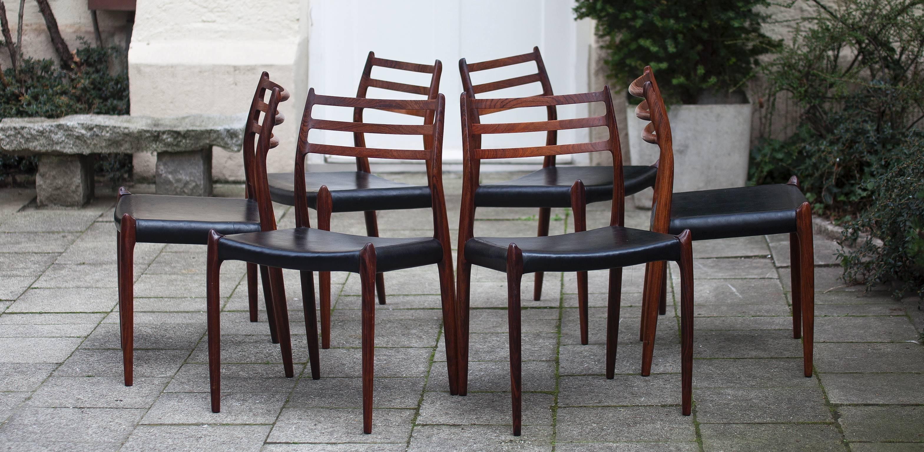 Fine handcrafted Mid-Century rosewood dining table set designed by Niels Otto Møller for JL Moller The extendable table model # 12, features exquisite rosewood on solid sculpted legs and the six rosewood chairs model # 78, with very sculptural