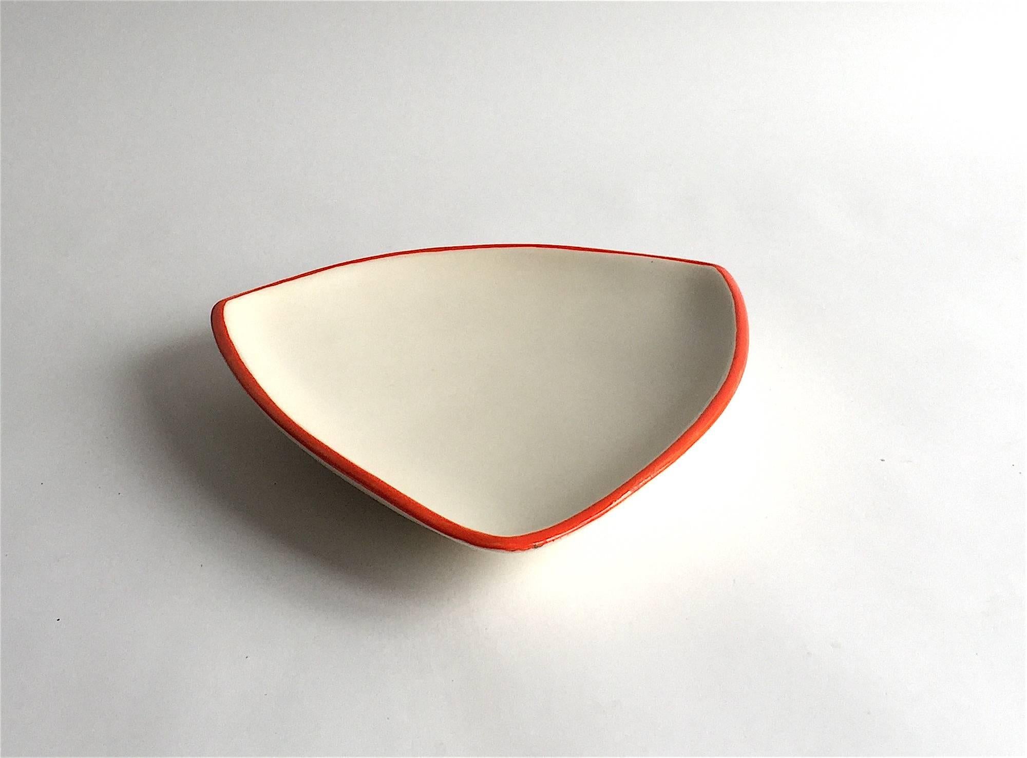 Denise Gatard (1927-1992).

This larger shell/ flat bowl is matte white on the inside and outside with an orange red line on the outer rim.

Denise Gatard: Sister of Georges Jouve was using strong organic shapes, too, but with delicate and fresh