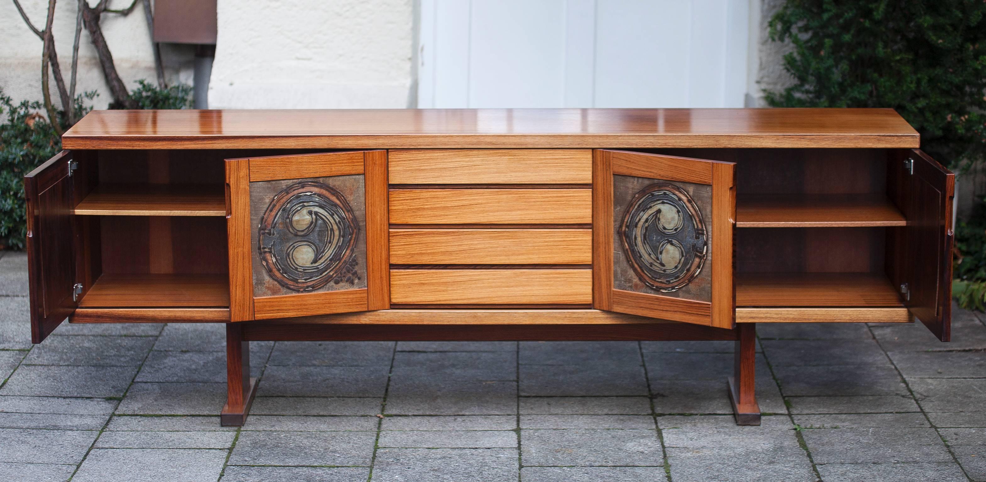 Rosewood sideboard with ceramic doors by Ox Art, Denmark, 1978.
Measures: H 76 W 215 D 46.