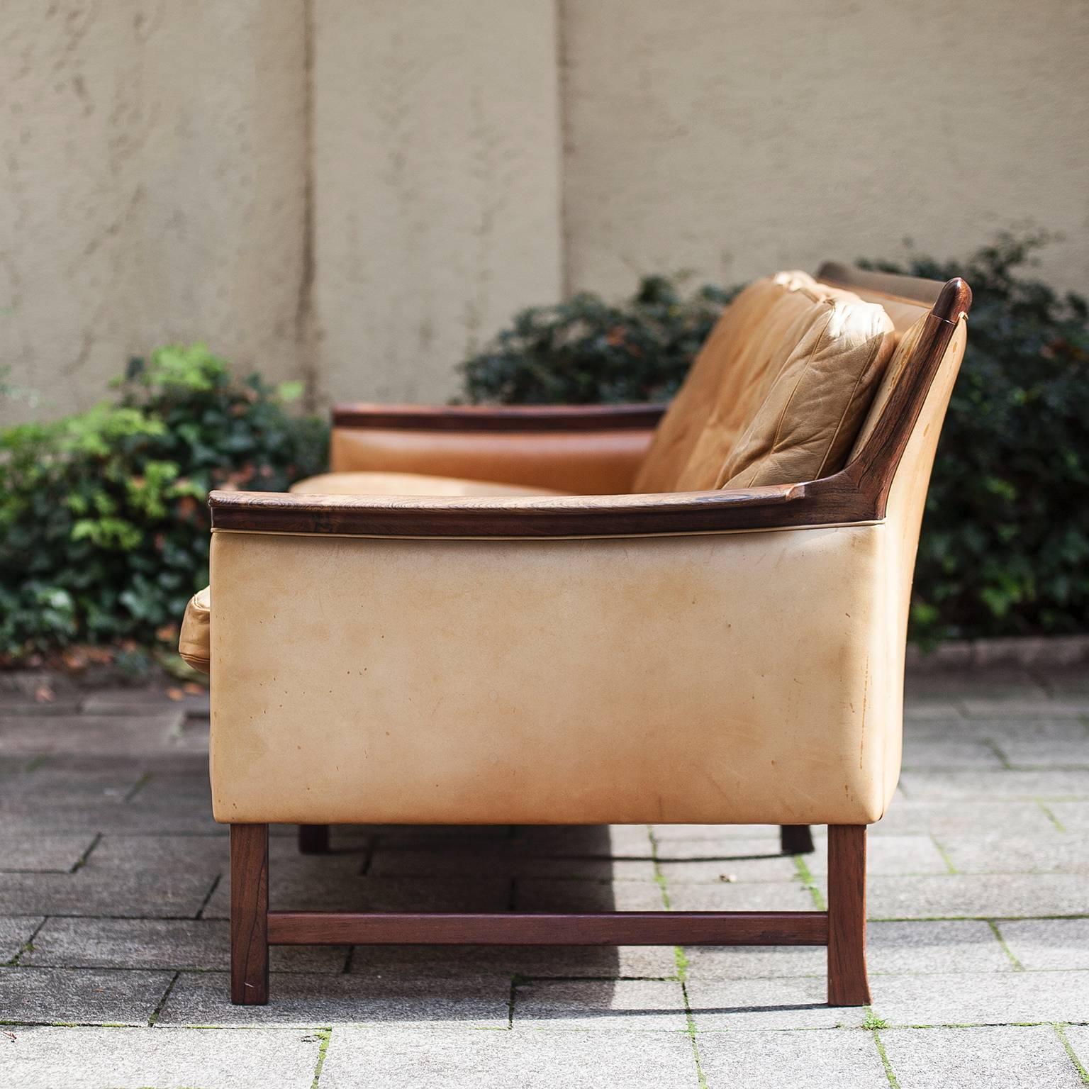 Very cozy and elegant rosewood and cognac natural leather by Torbjørn Afdal "Minerva" sofa for Bruksbo. This is a four-seat sofa from Scandinavian origin. Torbjørn Afdal designed it in 1965.

  