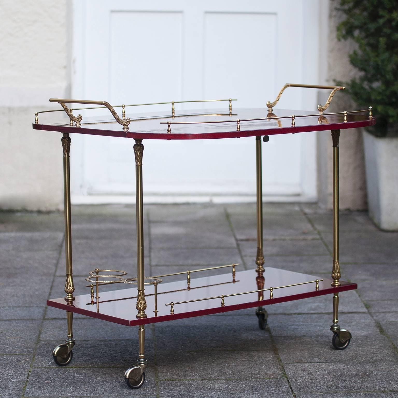 Elegant lacquered goatskin liquor trolley by Aldo Tura in emerald red. The sides can be fold up. The goatskin shows a stunning deep tone, which is in a very nice contrast with the elegant, well designed brass details. Manufactured in Milan,