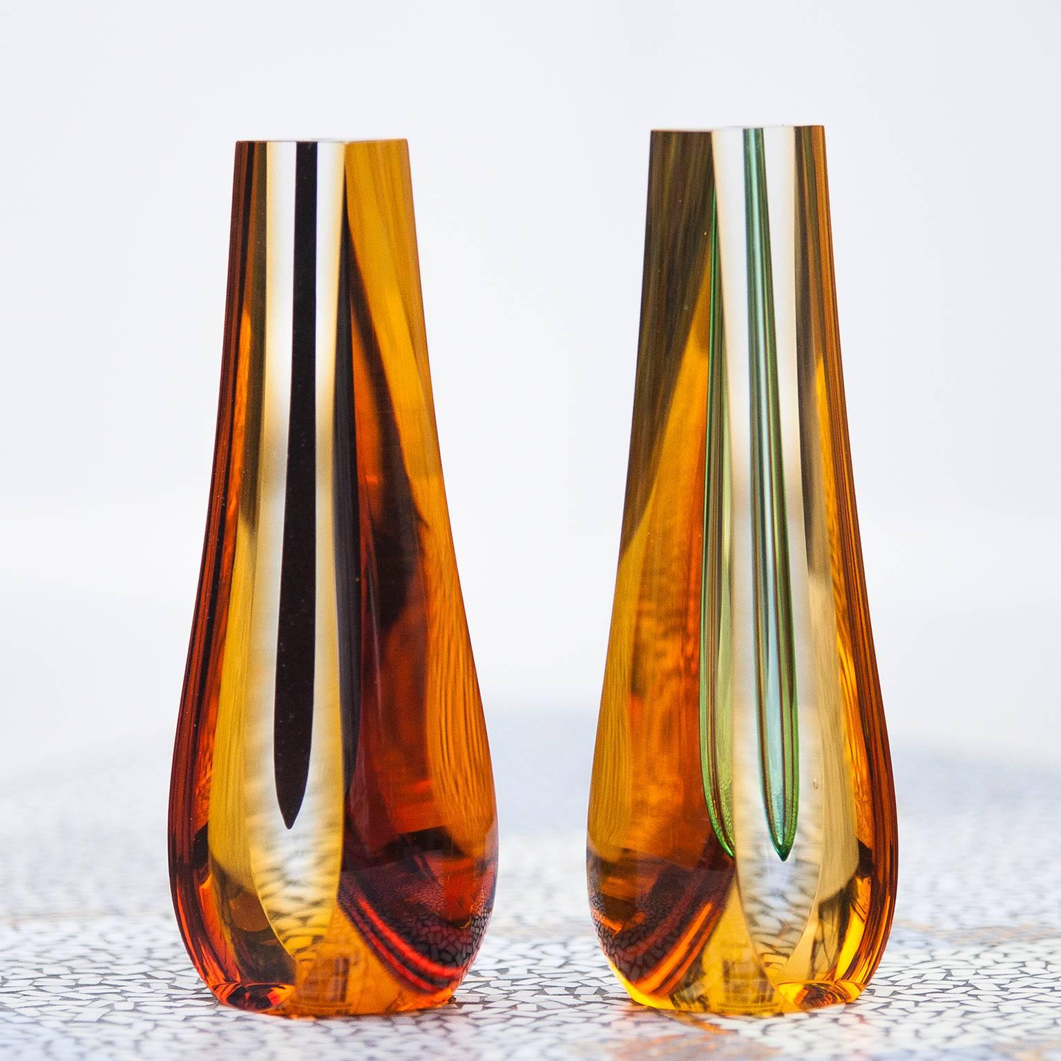 Set of two sculptural glass vases by Pavel Hlava, Czech 1960. A deep green and black teardrop is suspended in a clear and yellow glass form. The inner tubular core can be used as a vase, but this is more of a sculpture.
H 21.7 x B 5.5 x D 8 cm.
   