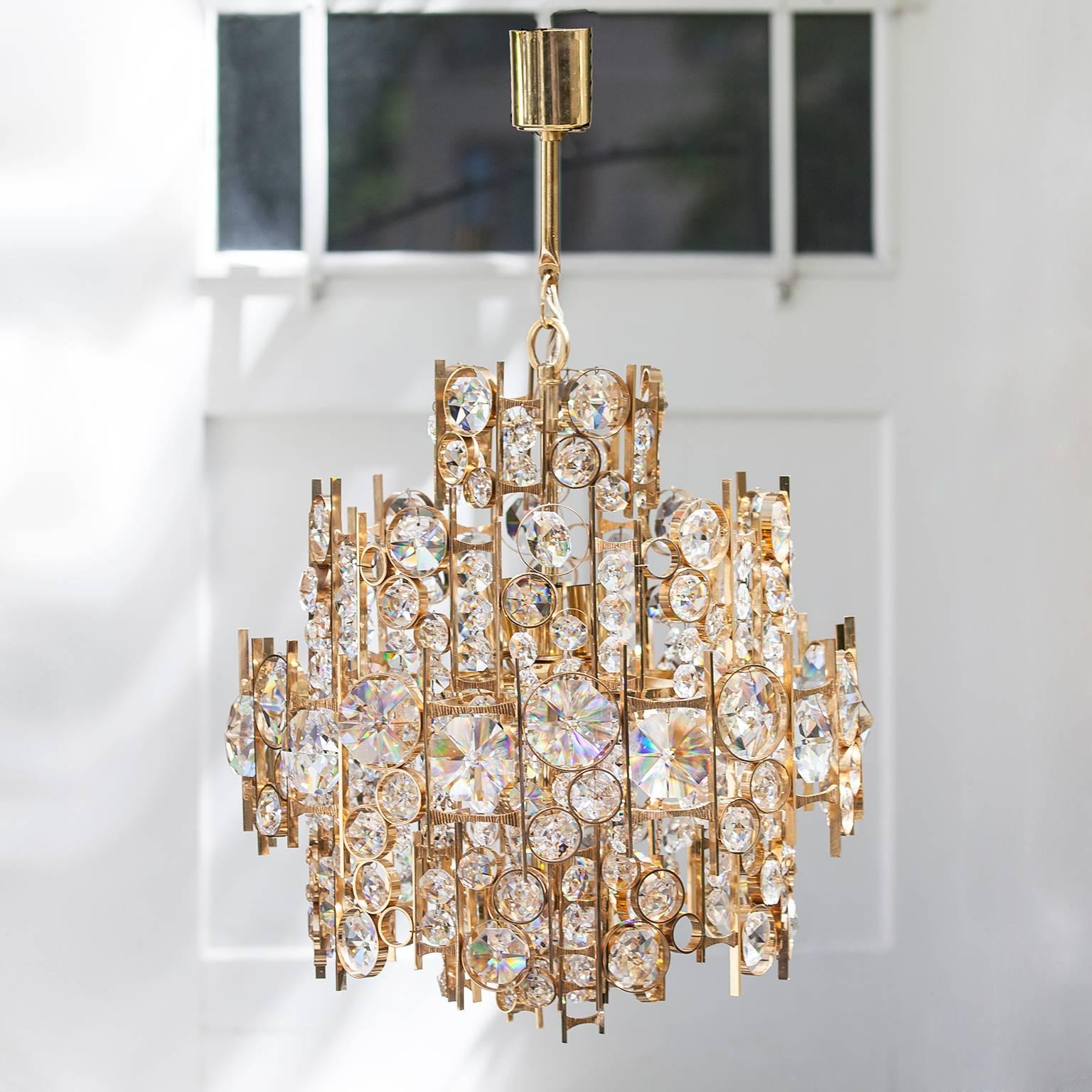 Fantastic chandelier with faceted crystal and gilded brass by Palwa, 24-karat gold-plated brass rings mounted with over 100 hand-cut and faceted crystals in three rows, creating an exquisite impression like crystaline seafoam, nine sockets. It has a