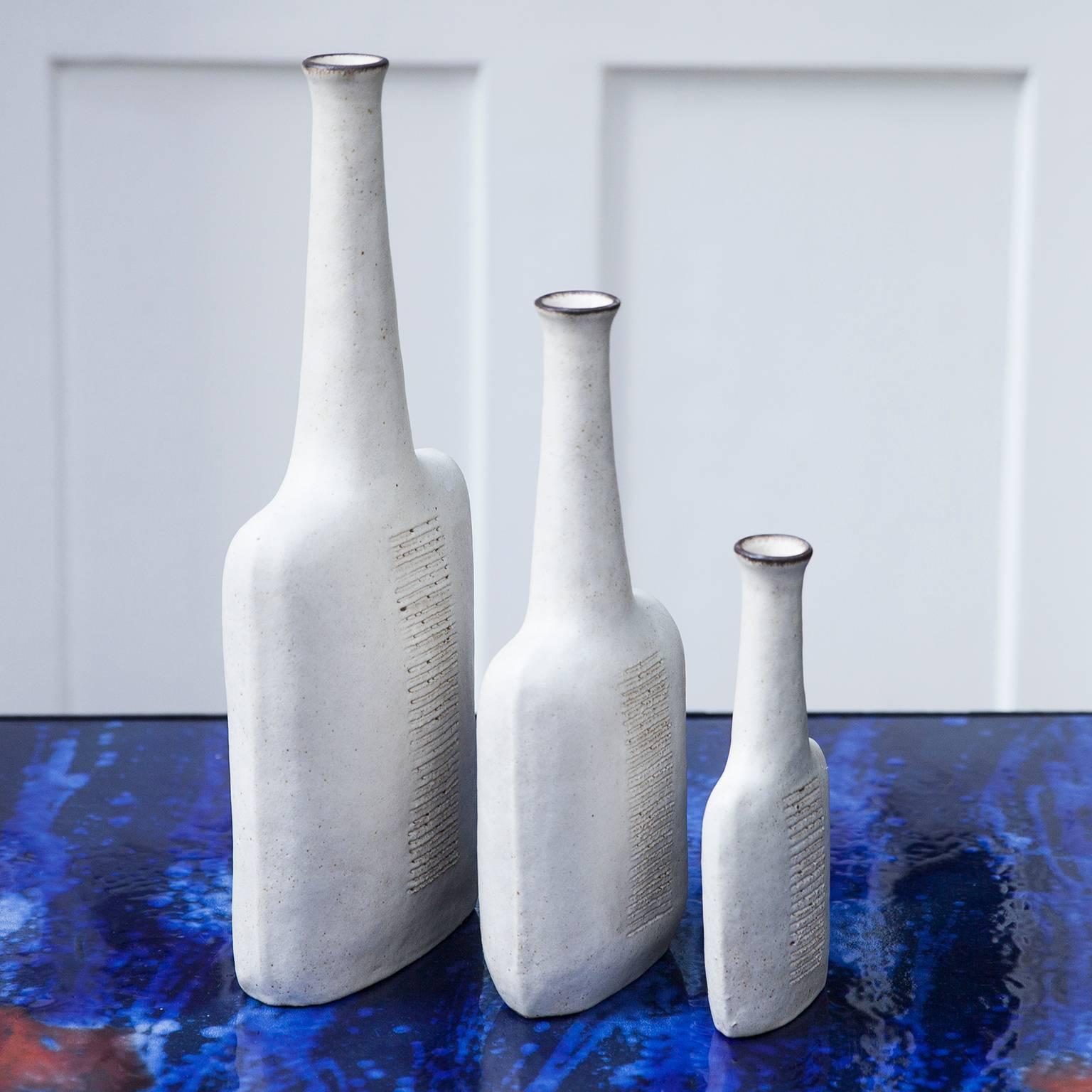 Fantastic set of three vases from the 1984 by Italian artist Bruno Gambone. Each example is with glazed signature to the underside. Complete size for all three pieces as follow: 
Measures: H 47 / W 20 / D 8 cm.
H 35.5 / W 15 / D 7 cm.
H 24 / W
