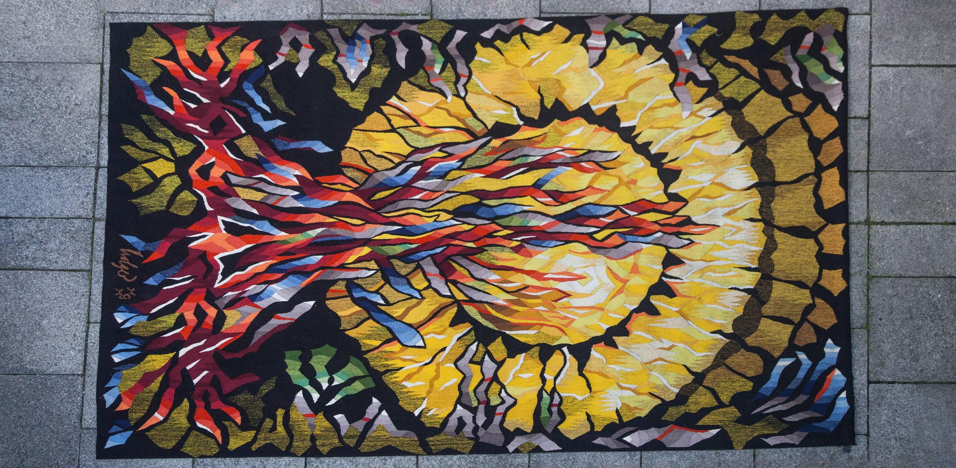 Wandteppich Feuersonne auf schwarzem Grund, entworfen von Dirk Holger (geboren 1939). Herstellung Münchner Gobelinmanufaktur, um 1970. 
Maße: 240 x 149 cm.