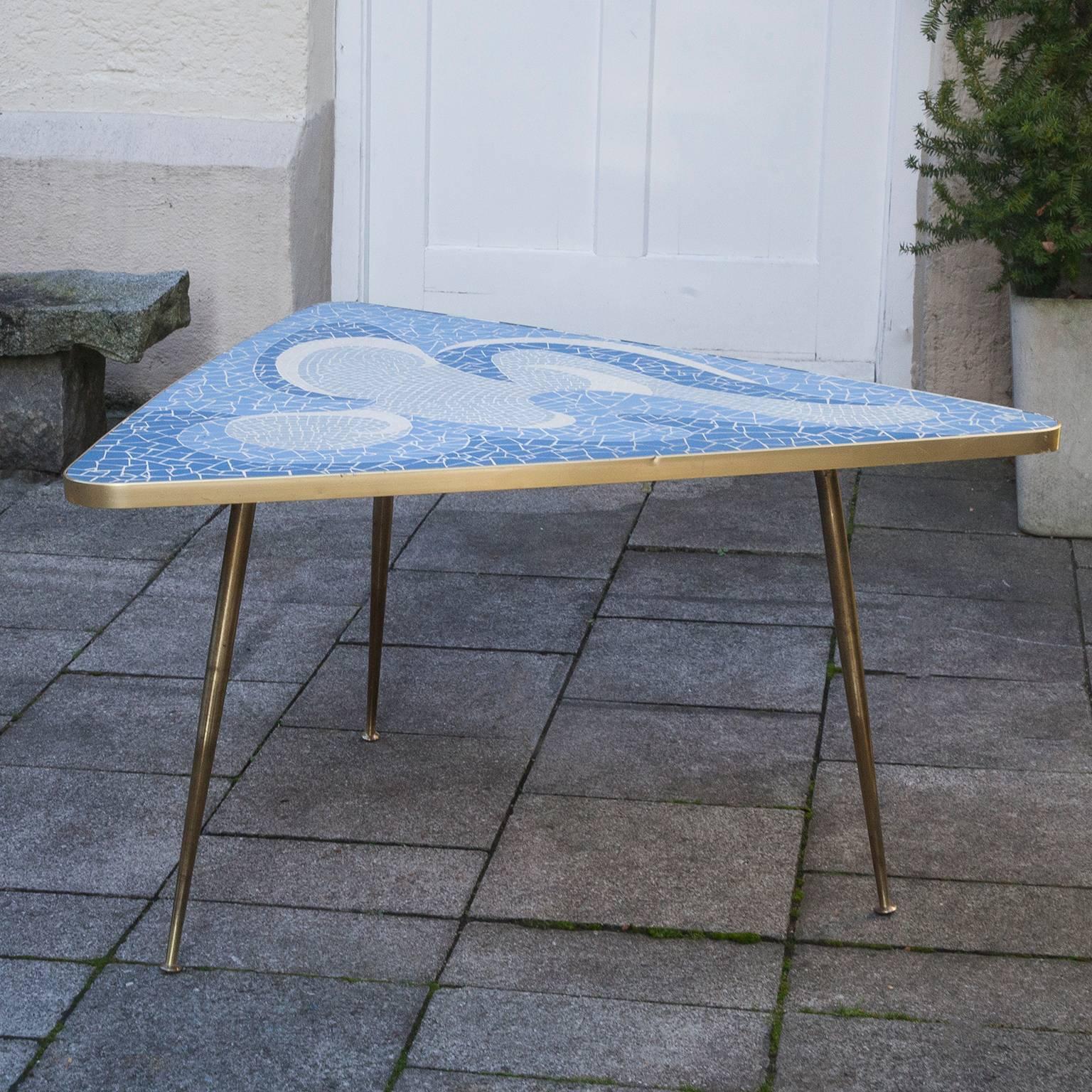 Mosaic triangle tripod coffee table by the German sculptor Berthold Muller, Oerlinghausen (1893-1979). The table has a triangle shaped tabletop and a beautiful mosaic pattern of stone mosaic tiles and a brass rim and tripod brass legs. The colors of