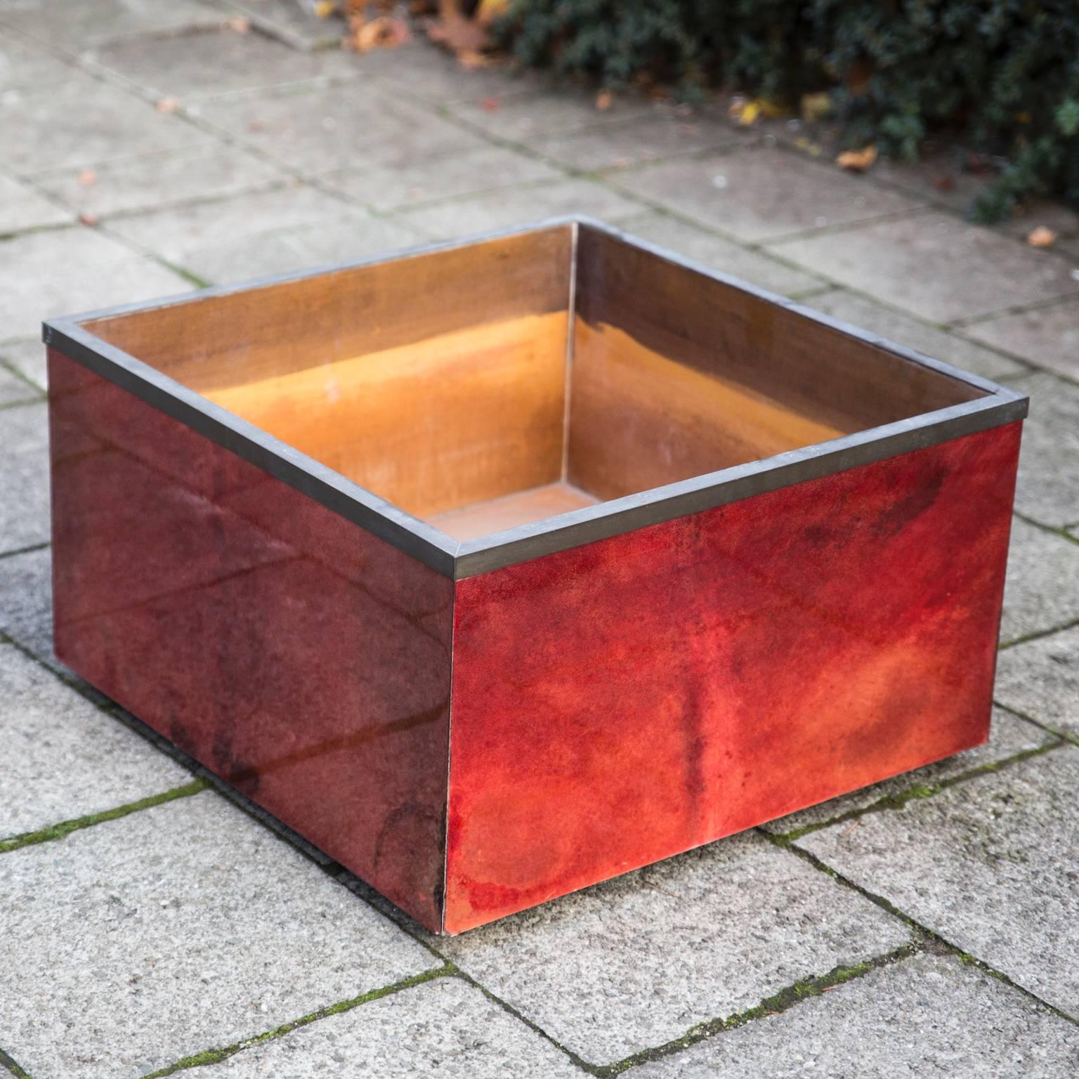 Elegant red squared goatskin planter with a brass border and four wheels by Aldo Tura, 1968.