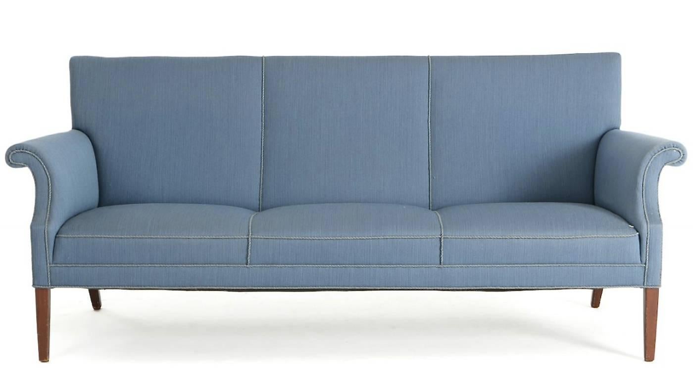 Freestanding three-seat sofa with tapering legs of mahogany. Seat, sides and back upholstered with light blue wool.