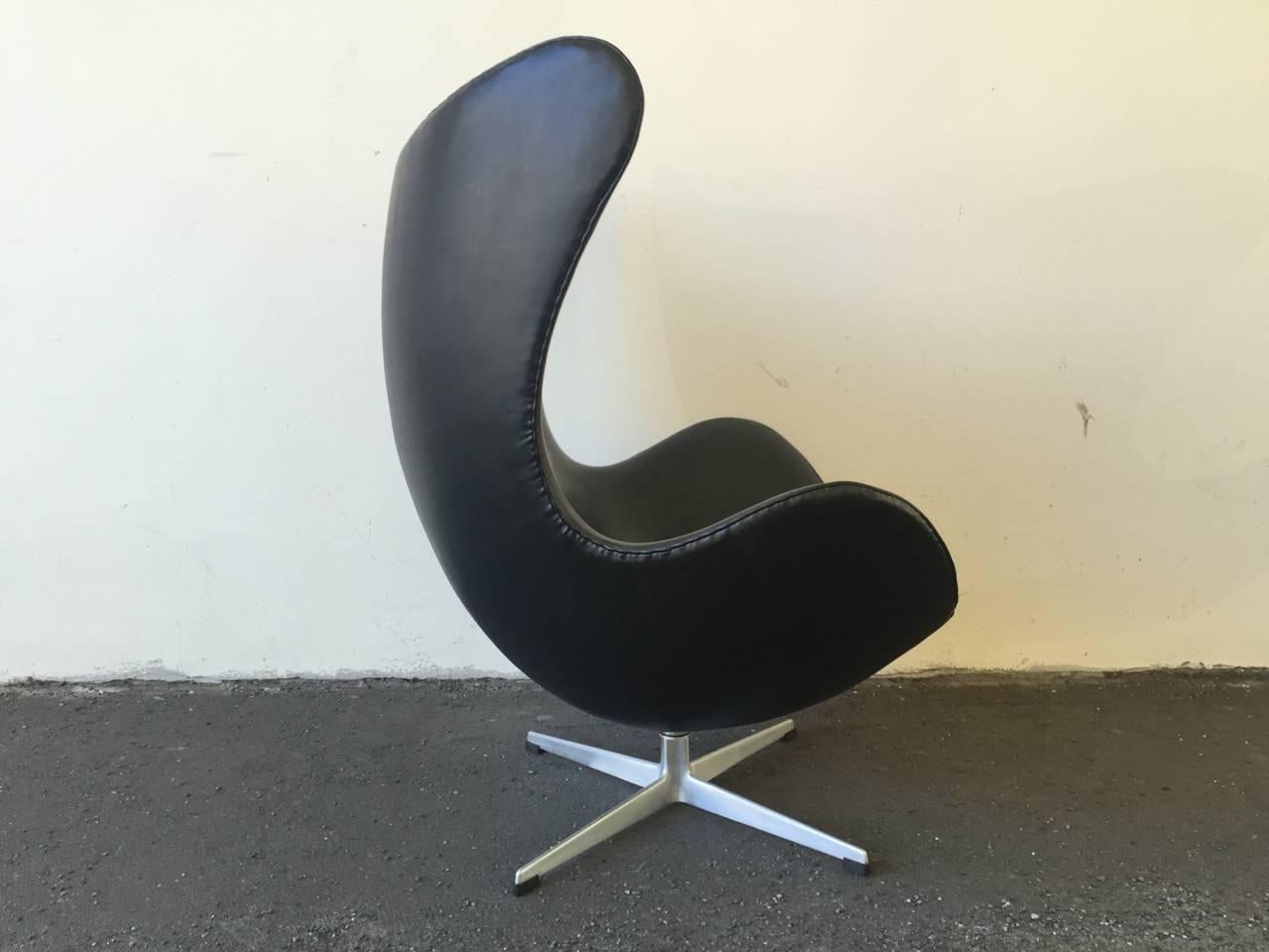 First edition Arne Jacobsen egg chair in good original condition. Original upholstery in black leatherette. Original foam in good condition.
