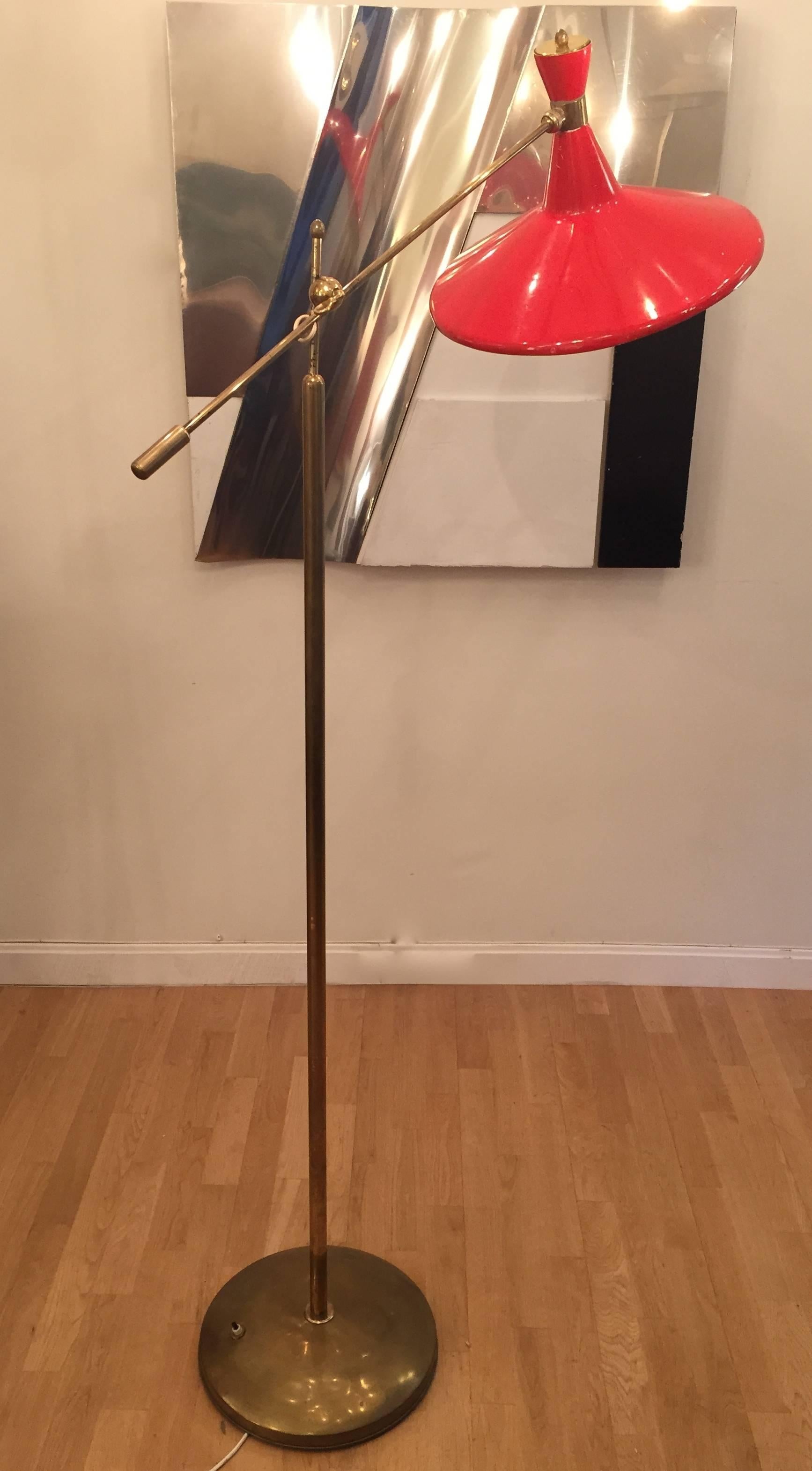 A 1950s Arteluce style floor lamp. Brass and enameled metal. Adjustable arm beautiful patina. Excellent original condition.