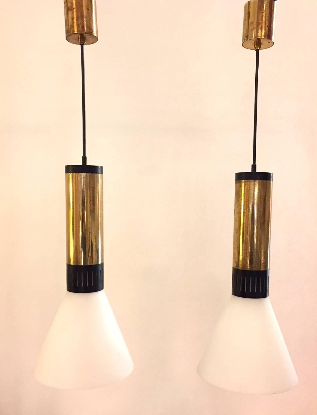 A fully original pair of Stilnovo pendants, produced in the 1960s. Brass, lacquered aluminium and frosted 