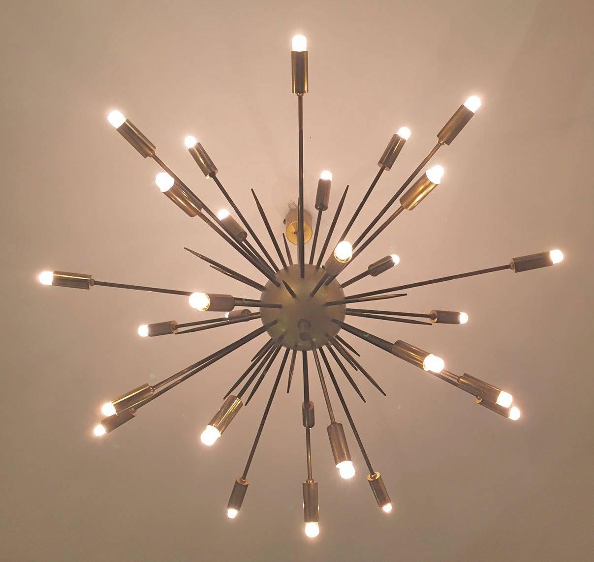 An original Italian Sputnik brass chandelier edited by Stilnovo in the 1950s.The lamp is composed of 24 arms attached to a brass ball and to a brass suspension stem. Excellent condition. 
 