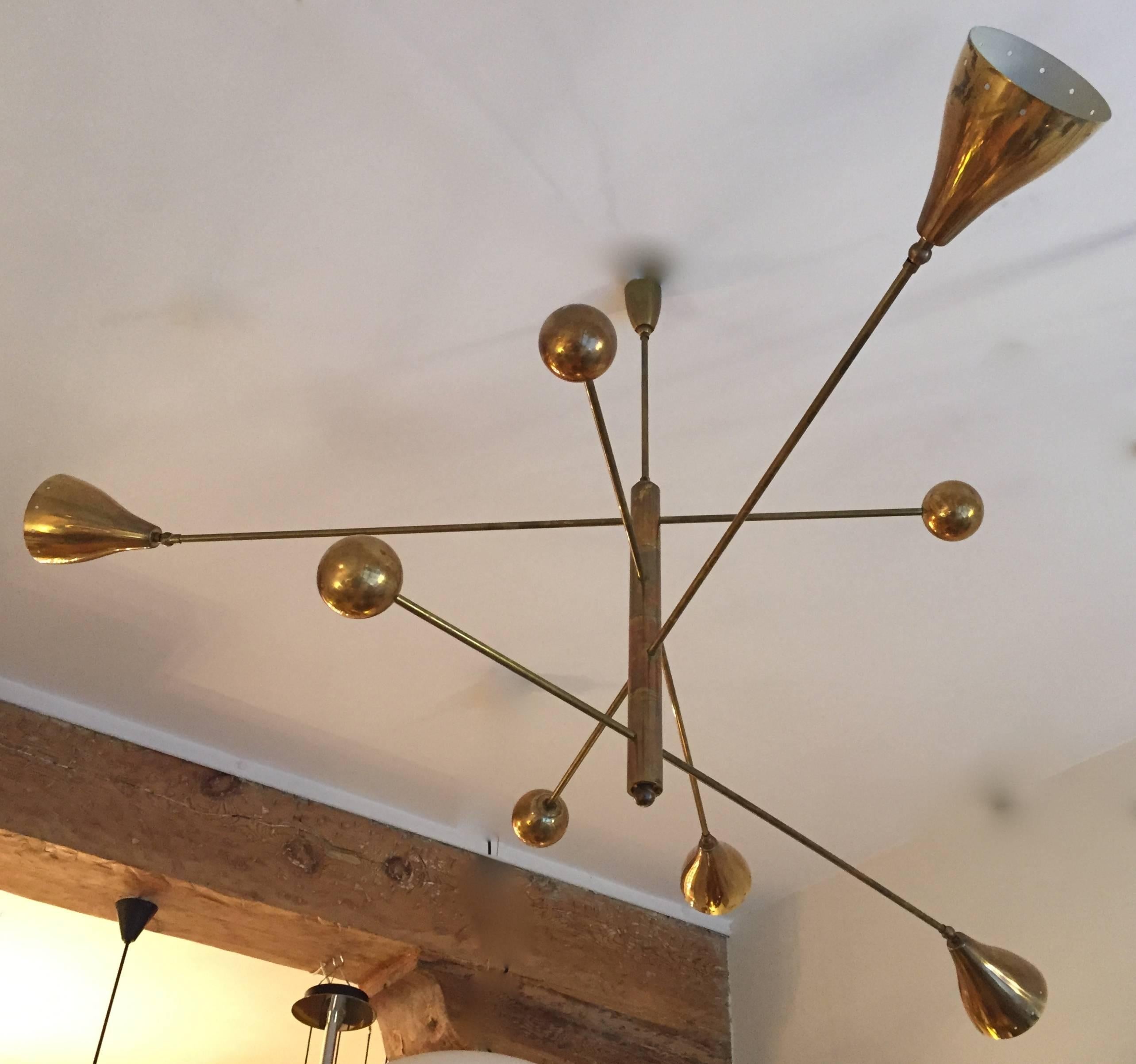 An impressive and very rare vintage four-shade mobile chandelier. Brass structure supporting four 160 degrees- rotating arms ended by adjustable shades and brass balls. Max. length 159 cm. Minimal length 123 cm. Rewired. Excellent condition.