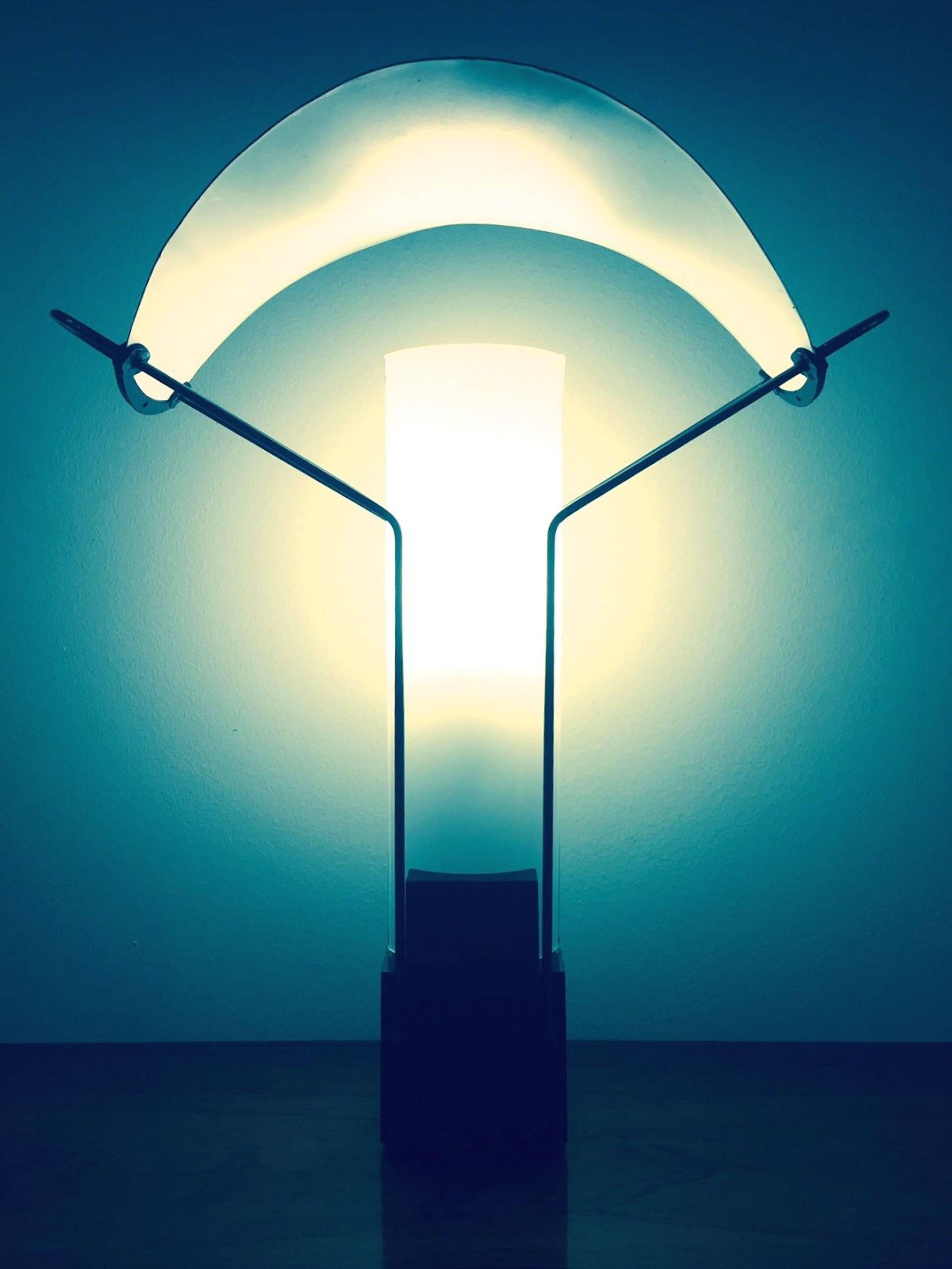 A table lamp designed by Perry King and Santiago Miralda for Arteluce in 1985. Metal base, opaline glass and copper shade.