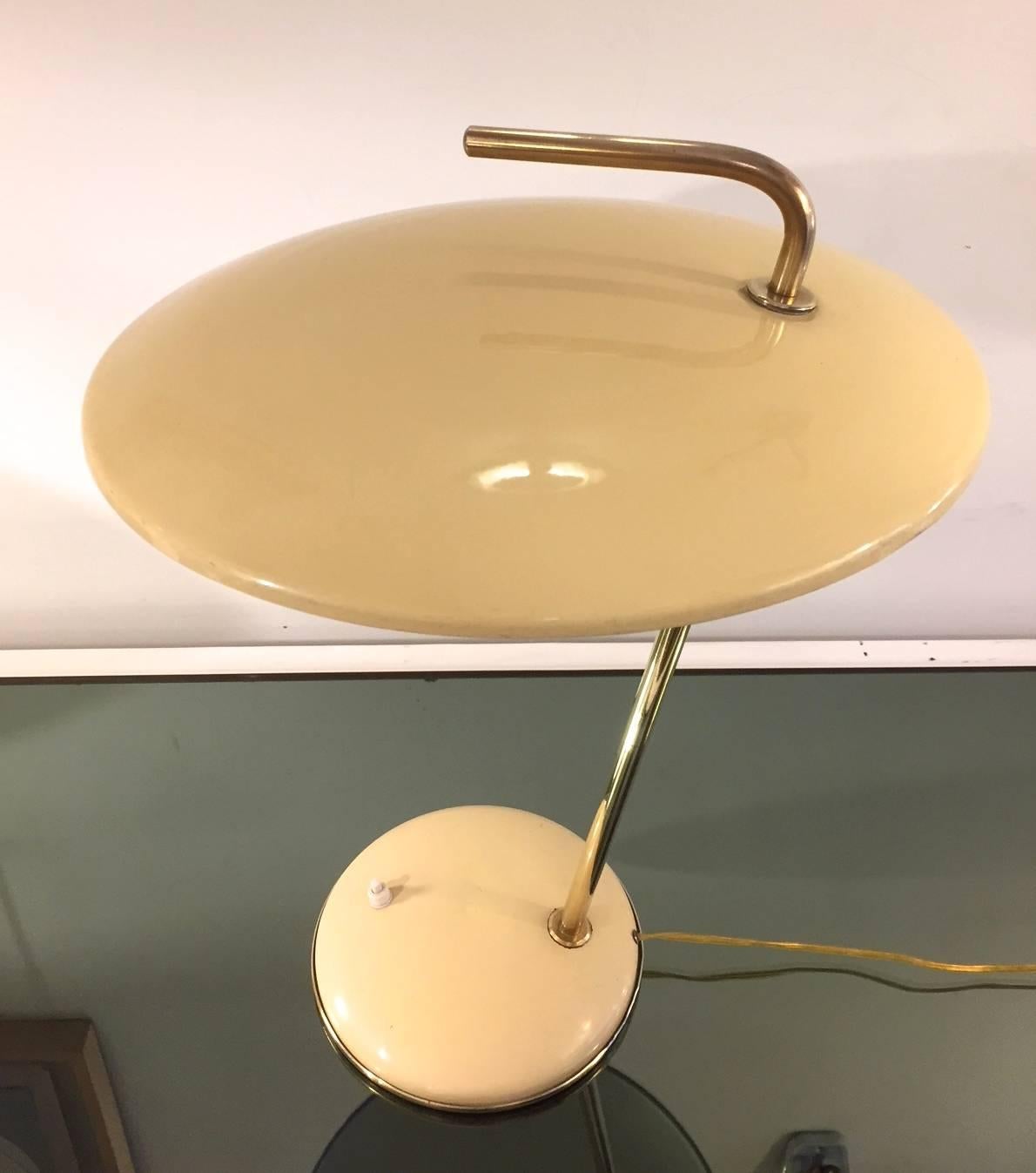 A table lamp designed by Nicolaj Diulgheroff in the forties. Bent brass and adjustable rod and round metal base. Enameled metal. Fully original.
   