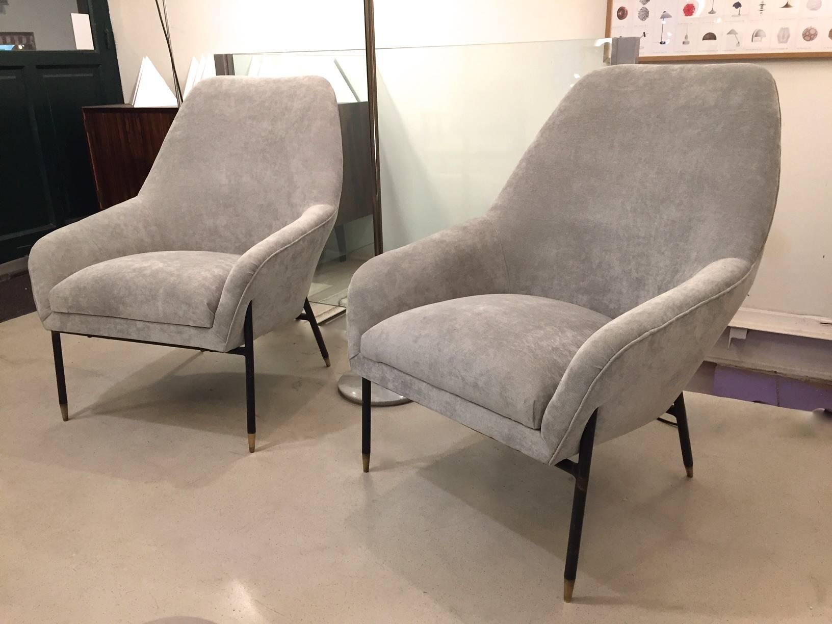 A pair of Italian armchairs edited in the 1950s. Reupholstered in grey velvet. Wood  structure and enameled meta legs with brass endings. Smart and very comfortable.