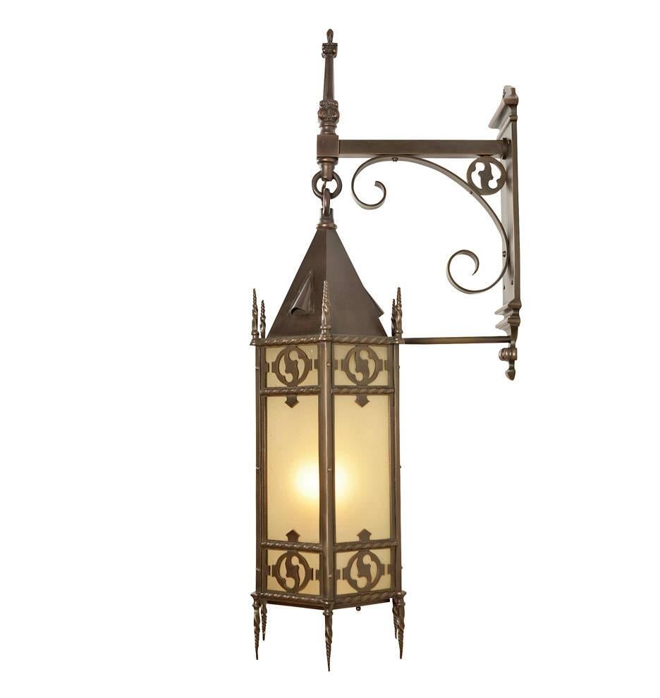 Made from cast bronze and filled with textured amber art glass, this 41" tall wall bracket is one of the most impressive entry lanterns in our collection. Combining classical and gothic revival elements, this six-sided fixture is a hallmark of