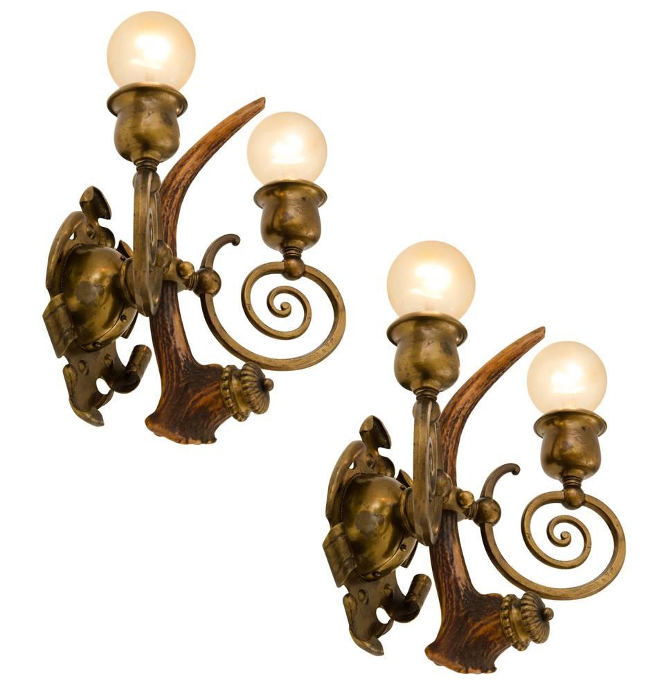 These are among the most unique and unusual sconces to ever pass through our restoration shop. They are beautiful, too, comprising beautifully made hand-wrought solid brass elements, swirling arms and well-oiled deer antlers. Although we do not know