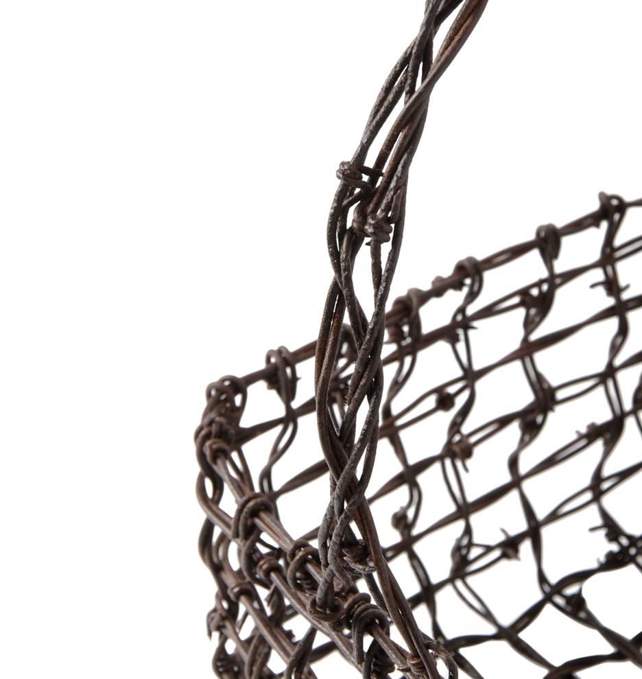 A unique expression of Folk or Trench Art, this hand basket is made of intricately woven barbed wire – an impressive task even for the soldier or artisan that made this unique piece. While we don't recommend keeping fresh fruit in this basket, it