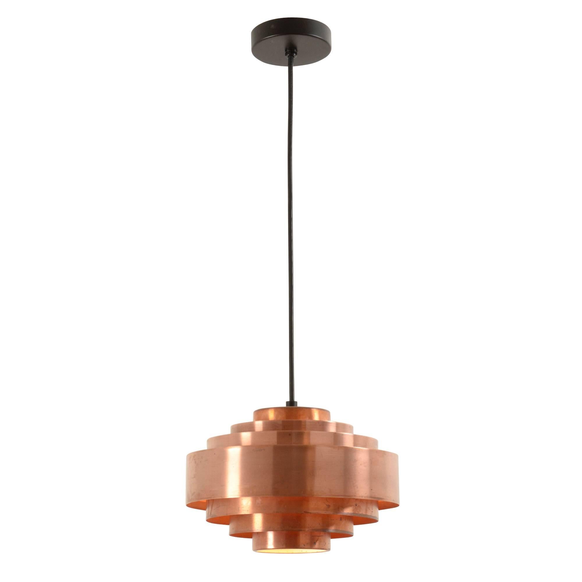 With its seven tiers of reflector rings, lightweight aluminum design, and original copper-tone lacquer, this spaceship-esque pendant is quintessentially Danish Modern. Despite its petite stature, it will still make a design statement in many home,