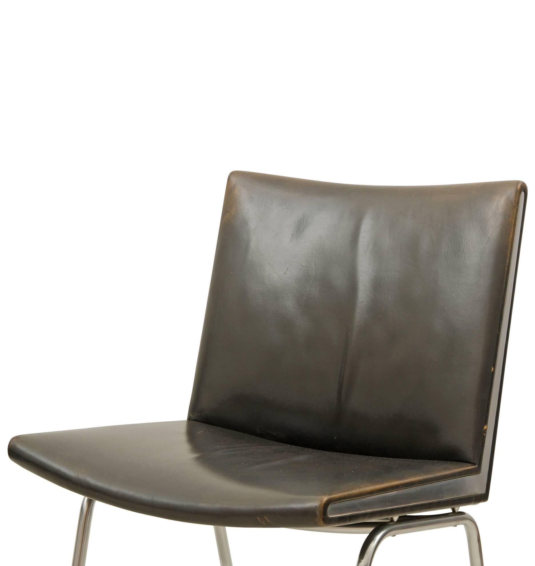 Designed by Hans J. Wegner, these leather and tubular chrome lounge chairs are quintessentially Danish in style and in use, as they were commissioned for the Kastrup Airport in Copenhagen. The chairs were manufactured by A.P. Stolen from