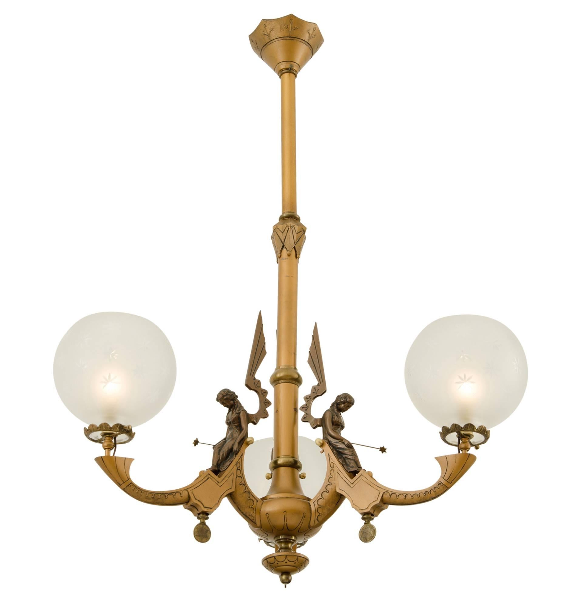 A rare and remarkable find, this three-light Neo-Grec chandelier is totally original, down to the etched wheel-cut shades, the original gold and bronze gilt finish and, best of all, the incredible cast bronze Fairies.

Figural ceiling fixtures are
