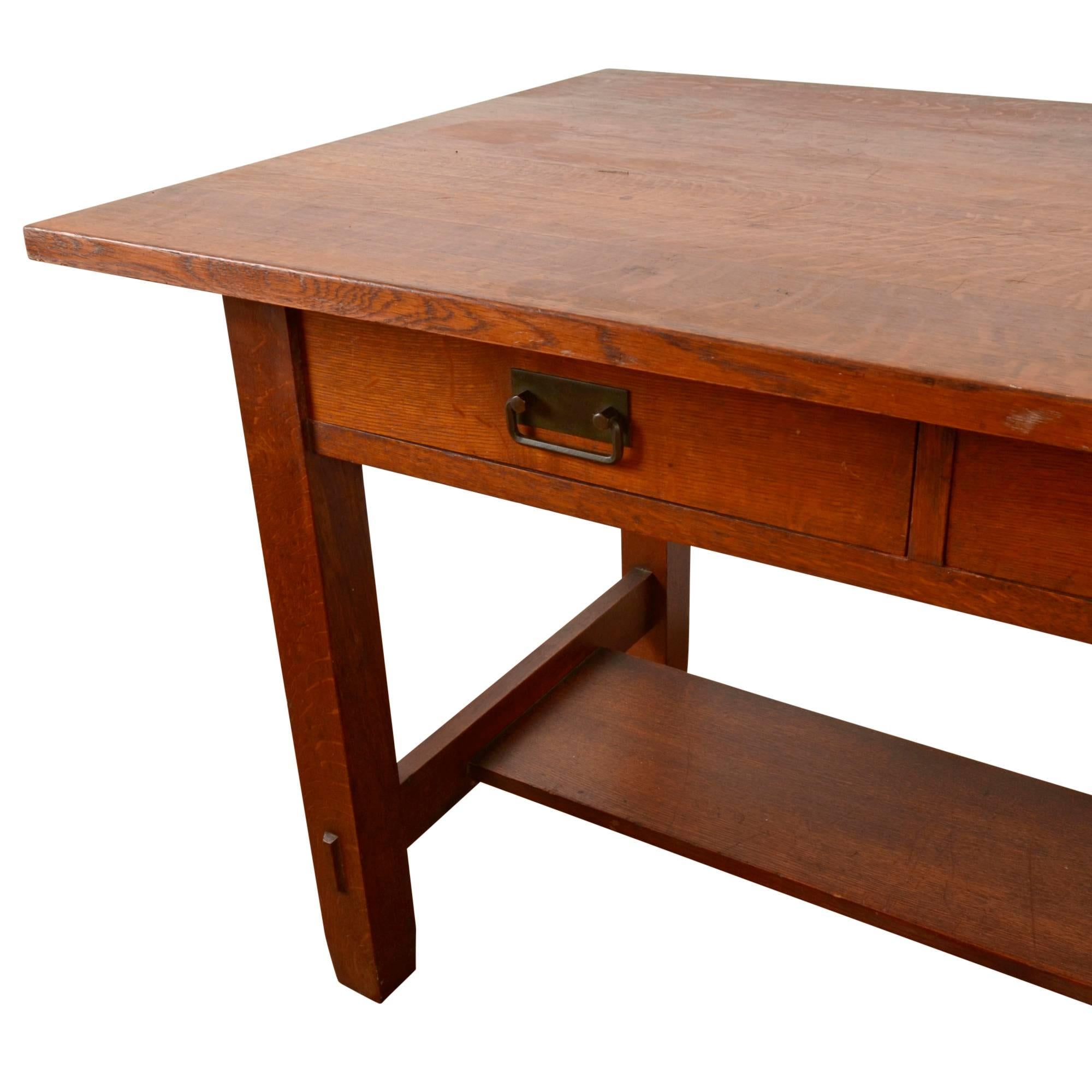 Sturdy and hard working, it is easy to imagine this handsome oak stickley style library desk in its original setting: an Arts & Crafts style library, filled with dusty, leather-bound volumes. Though unattributed and unsigned, this piece boasts