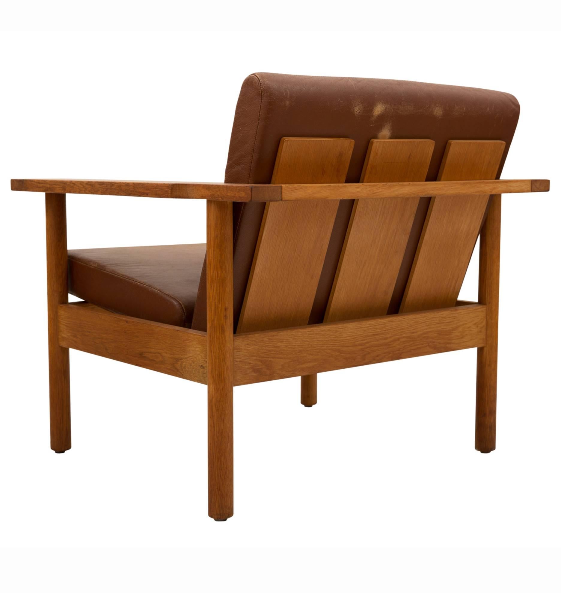 Similar to designs by Scandinavian greats like Borge Mogensen, these gorgeous solid oak and bentwood armchairs feature fantastic mid-century forms, simple construction and their original leather cushions. The seats themselves are rather unique: