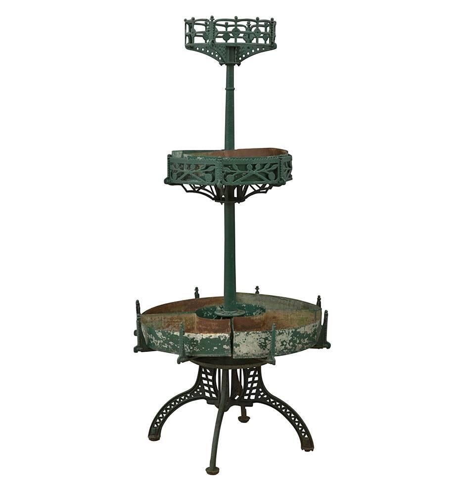 Rescued from a Victorian flower shop, this intricately cast iron stand features three tiers (removable galvanized tin trays on the lower two) and fantastically worn original green finish. Possibly Bradley & Hubbard.