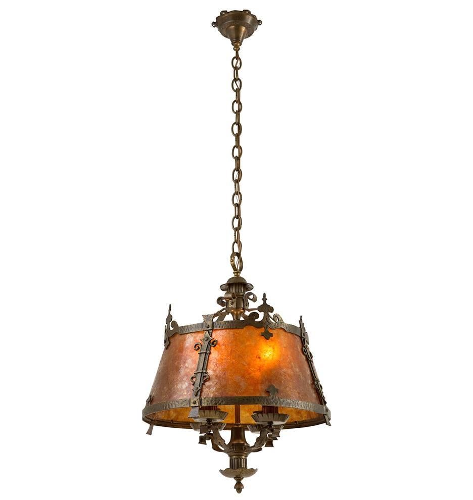 This magnificent handmade wrought brass chandelier dates from the late 1920s, the height of Spanish Revival or Monterey style and from California, the place where that style reigned supreme. It manages to put together an abundance of rather typical