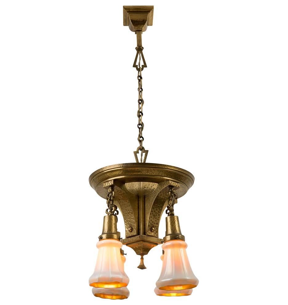 The hearty, hammered finish of this awe-inspiring Arts & Crafts chandelier is complimented perfectly with a set of signed gild-lined iridescent shades. While the shades will get plenty of well-deserved attention, don't forget to notice the details