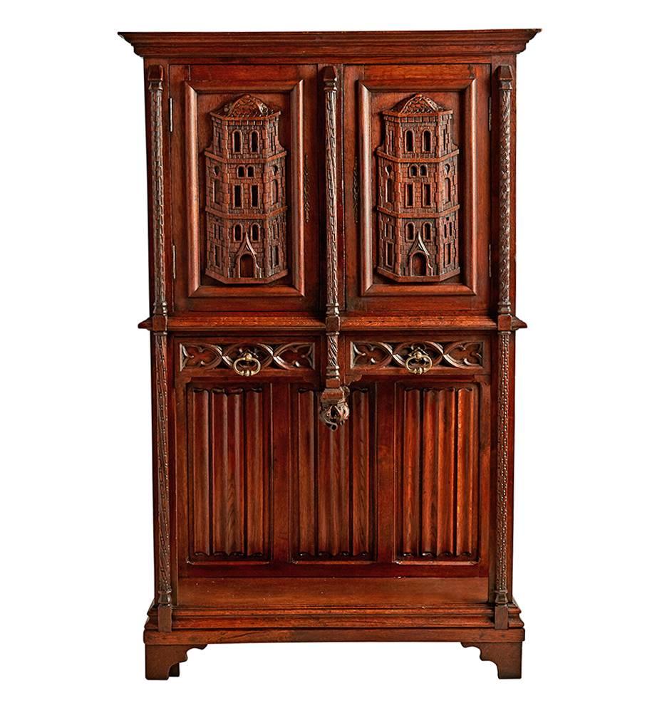 This incredible oak sideboard features a mix of Revival styles and patterns, paying homage to Gothic and Renaissance motifs, capped by carved stone towers on the doors and side-panels. This cabinet was found on a trip through Europe, and it is