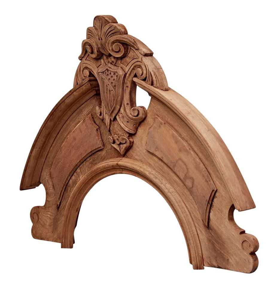 Over 150 years old, this carved walnut architectural remnant would have been found decorating the window of an early American municipal building or impressive manor. This piece would have capped a wooden framed oval window and has been stripped of